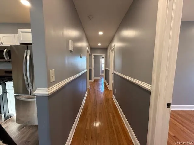 Corridor with dark wood-type flooring and recessed lighting Corridor with dark wood-type flooring and recessed lighting