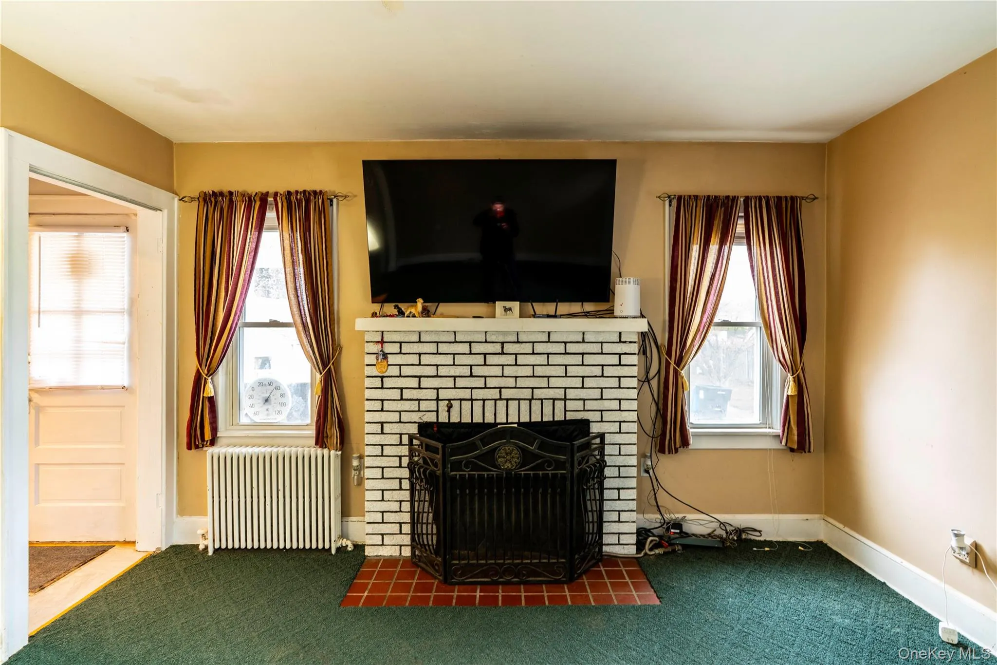 Living area featuring a white brick fireplace (not currently used) with a terracotta tile hearth Living area featuring a white brick fireplace (not currently used) with a terracotta tile hearth