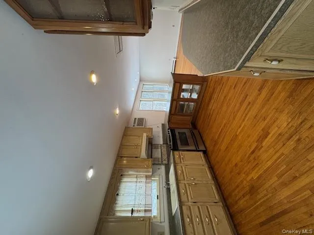 Kitchen featuring glass insert cabinets, a peninsula, dark wood finished floors, dark countertops, and range Kitchen featuring glass insert cabinets, a peninsula, dark wood finished floors, dark countertops, and range