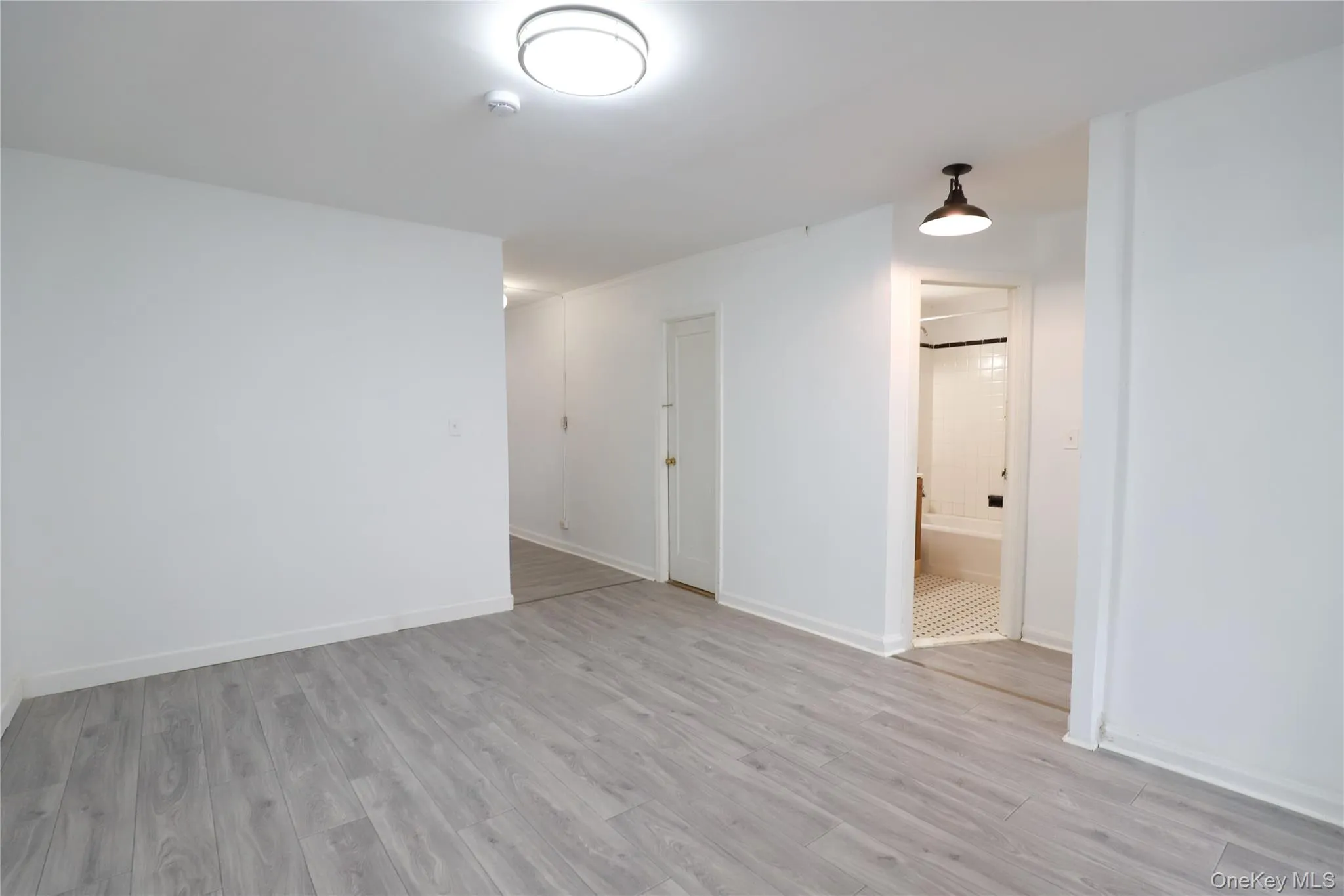 Empty room with light wood-style floors and baseboards Empty room with light wood-style floors and baseboards