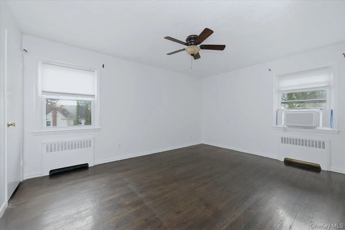 Wood floors, two windows, ceiling fan and closet Wood floors, two windows, ceiling fan and closet