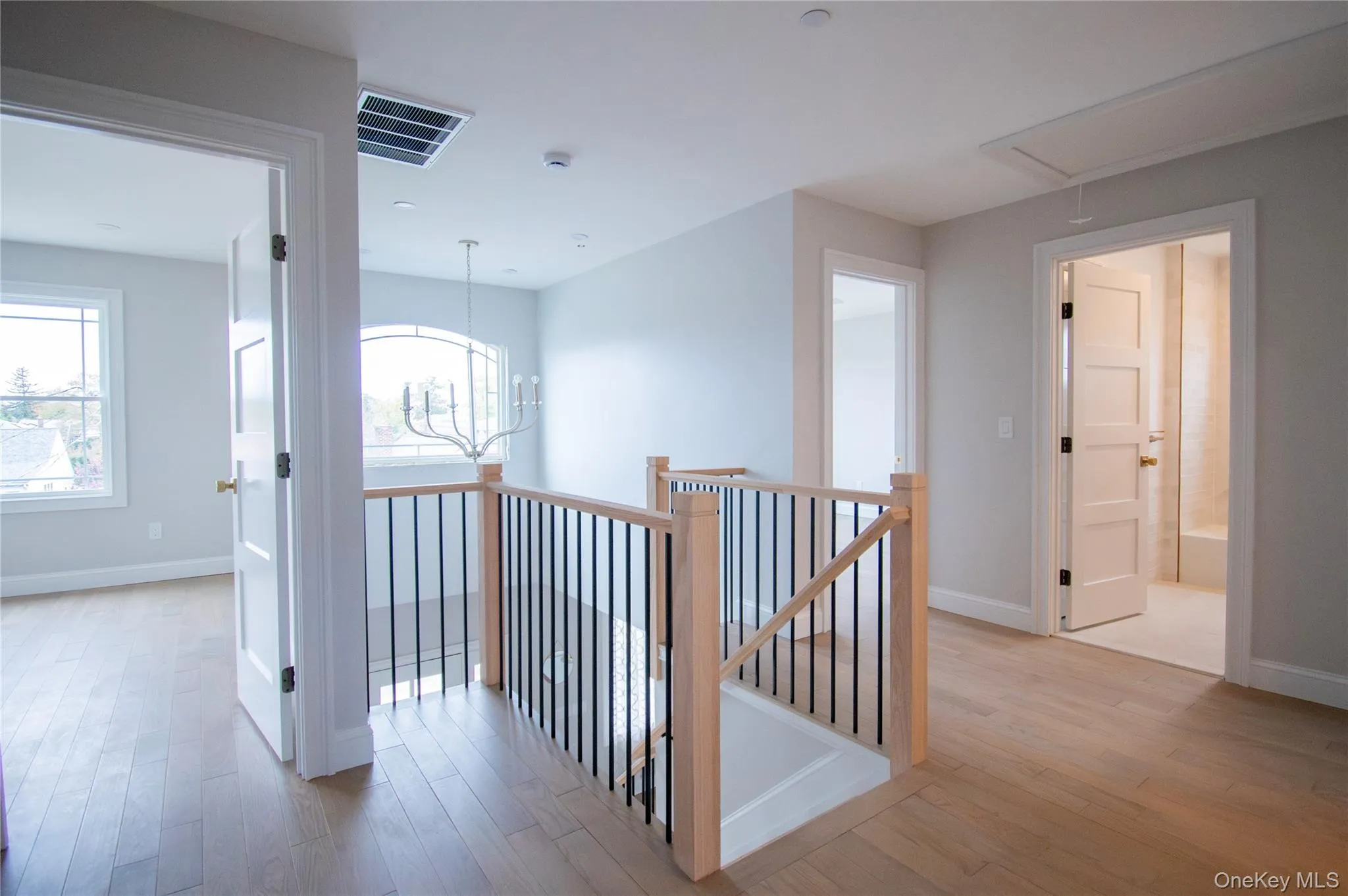 Hallway featuring an upstairs landing, attic access, light wood finished floors, and healthy amount of natural light Hallway featuring an upstairs landing, attic access, light wood finished floors, and healthy amount of natural light