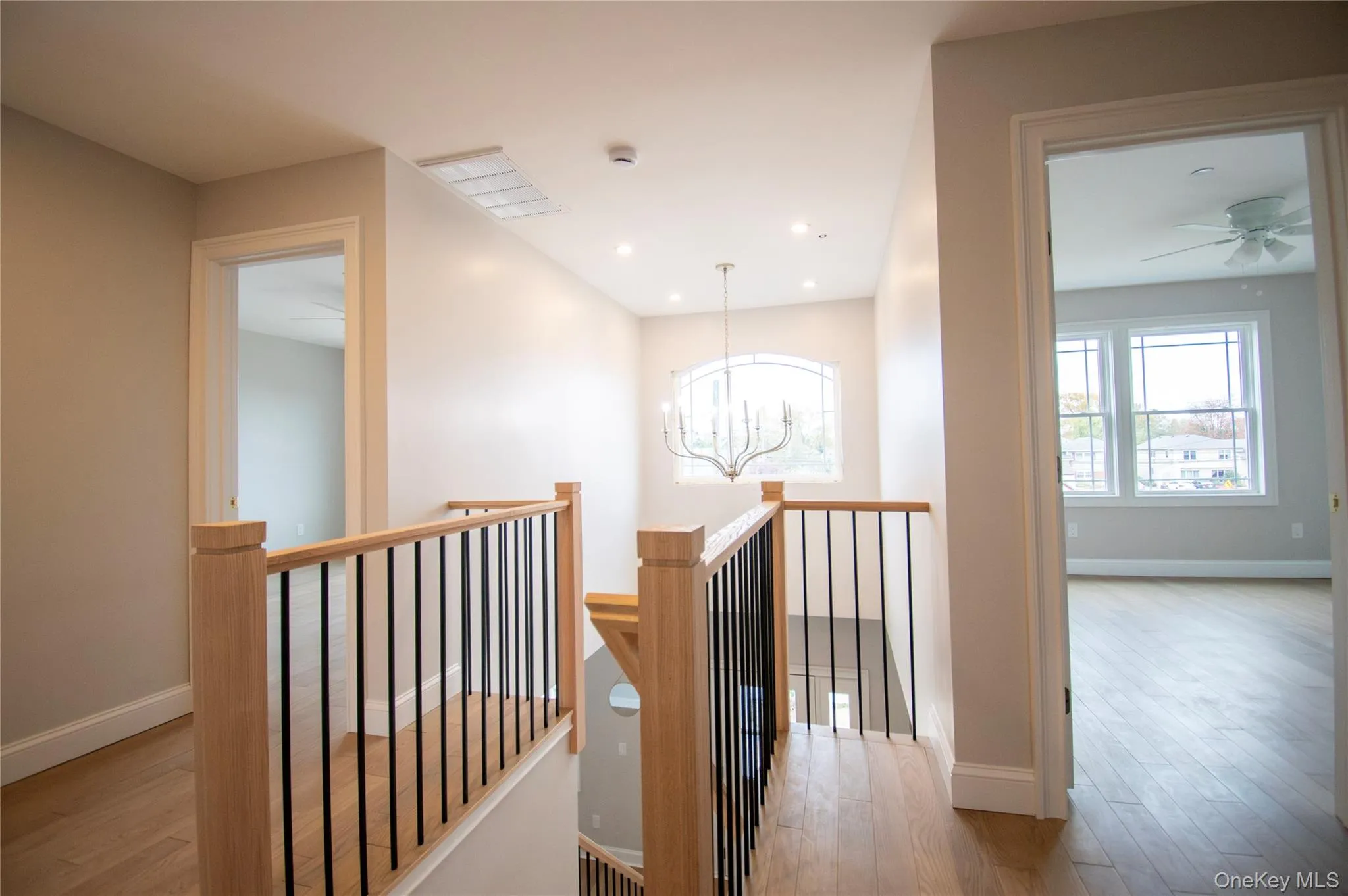 Hall with a chandelier, an upstairs landing, light wood-style floors, and recessed lighting Hall with a chandelier, an upstairs landing, light wood-style floors, and recessed lighting