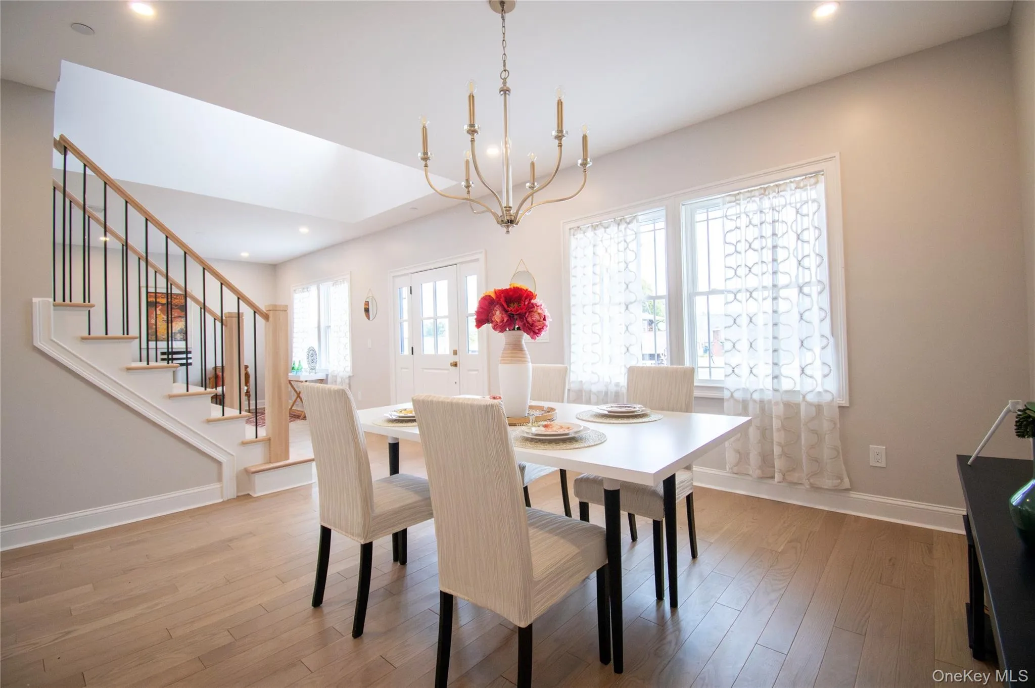 Dining room featuring recessed lighting, light wood-type flooring, stairway, and a chandelier Dining room featuring recessed lighting, light wood-type flooring, stairway, and a chandelier
