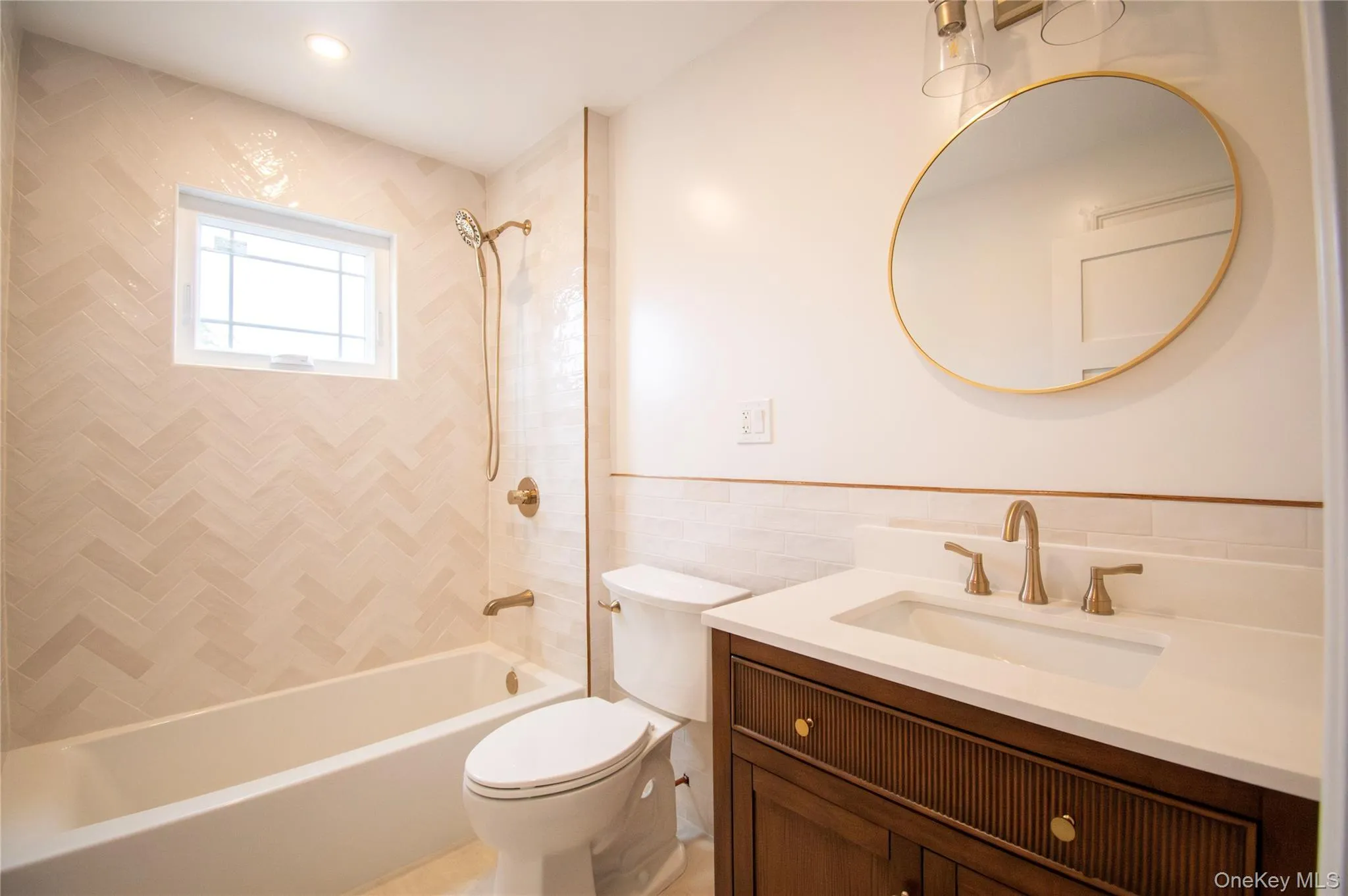Bathroom with vanity, shower / tub combination, and tile walls Bathroom with vanity, shower / tub combination, and tile walls