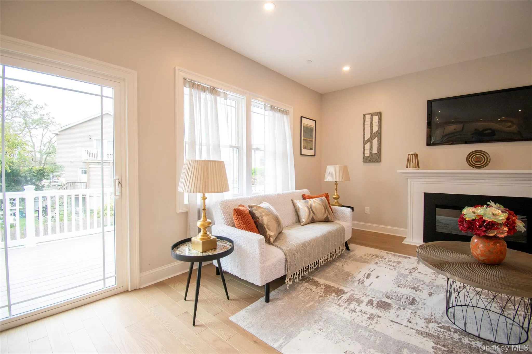 Living room with wood finished floors, a fireplace with flush hearth, and recessed lighting Living room with wood finished floors, a fireplace with flush hearth, and recessed lighting