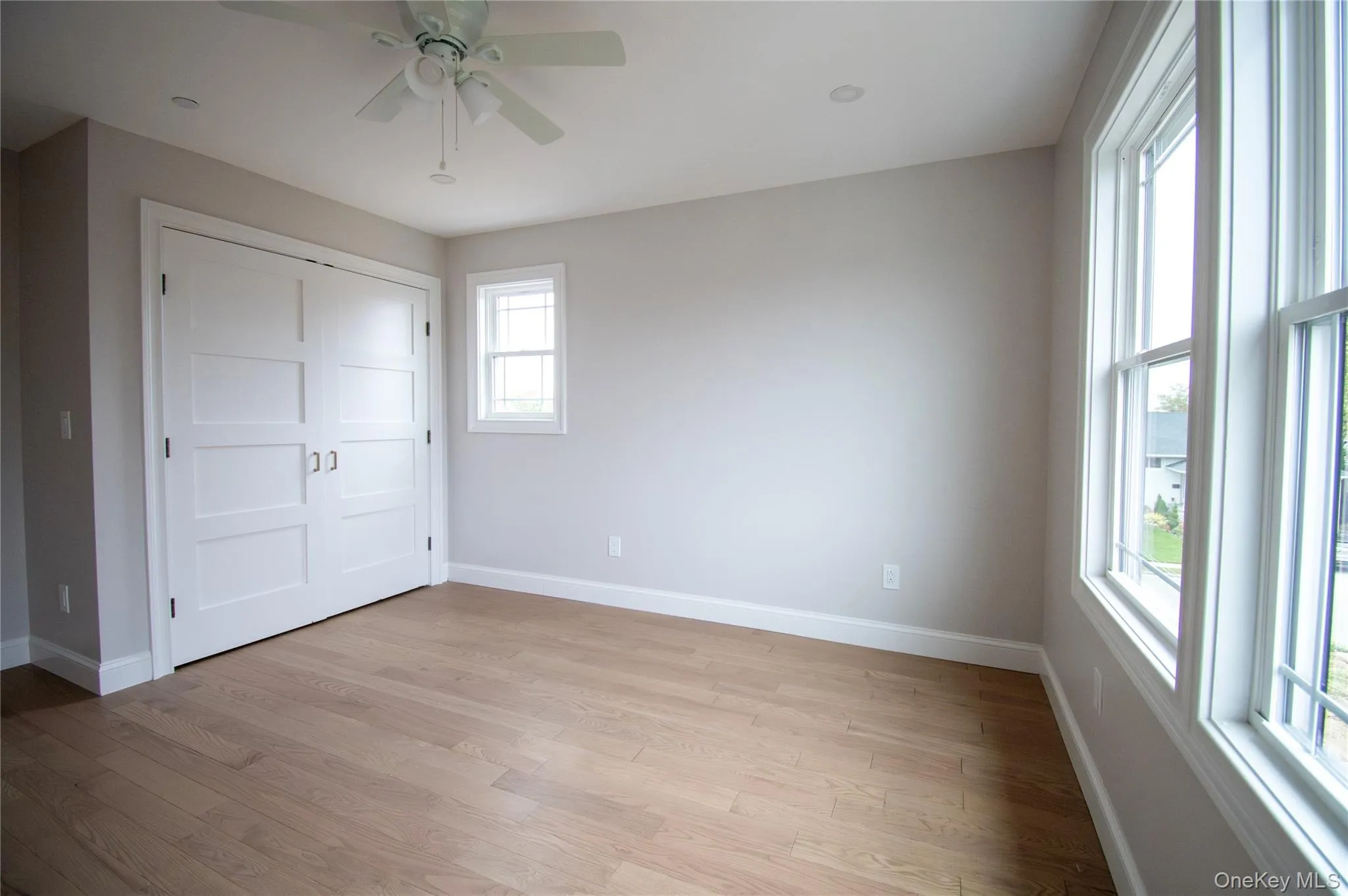 Unfurnished bedroom featuring light wood-style flooring, ceiling fan, and a closet Unfurnished bedroom featuring light wood-style flooring, ceiling fan, and a closet