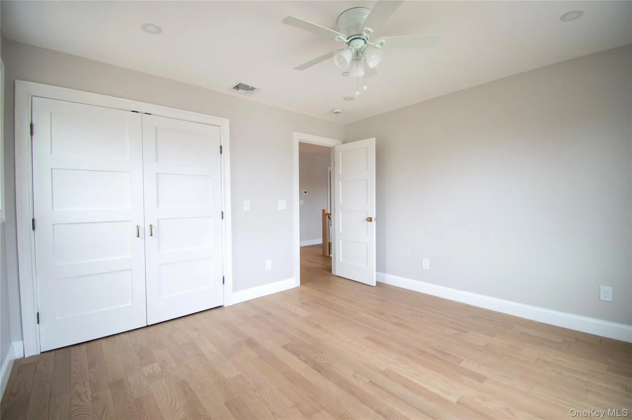 Unfurnished bedroom with light wood-style flooring, a ceiling fan, and a closet Unfurnished bedroom with light wood-style flooring, a ceiling fan, and a closet