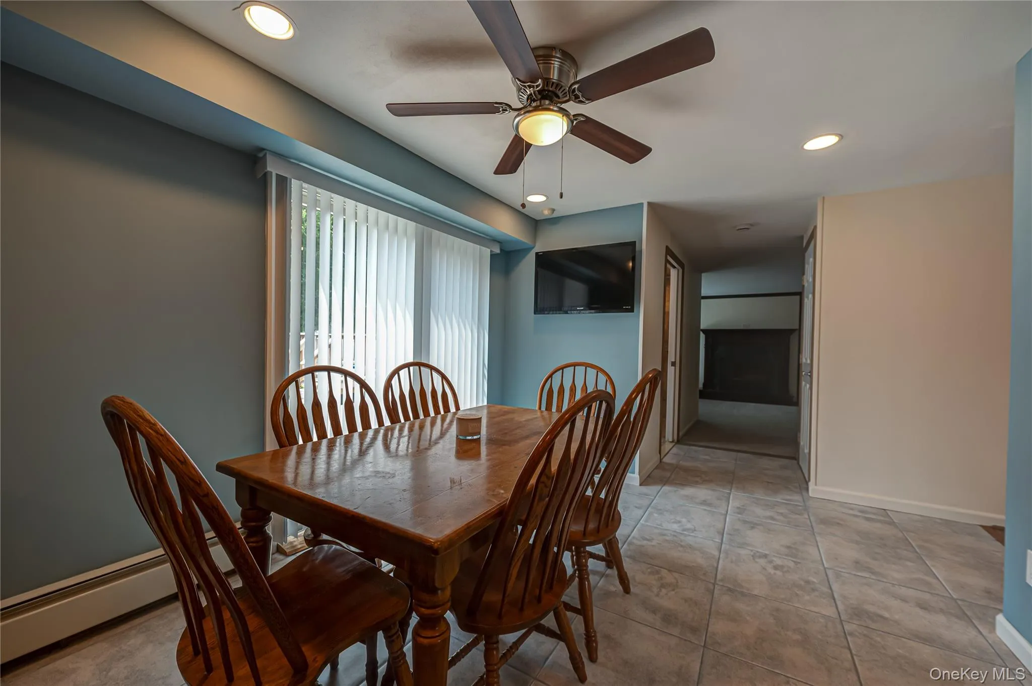 Dining area featuring tiled flooring, recessed ceiling lighting, a ceiling fan with integrated light, and vertical blinds Dining area featuring tiled flooring, recessed ceiling lighting, a ceiling fan with integrated light, and vertical blinds