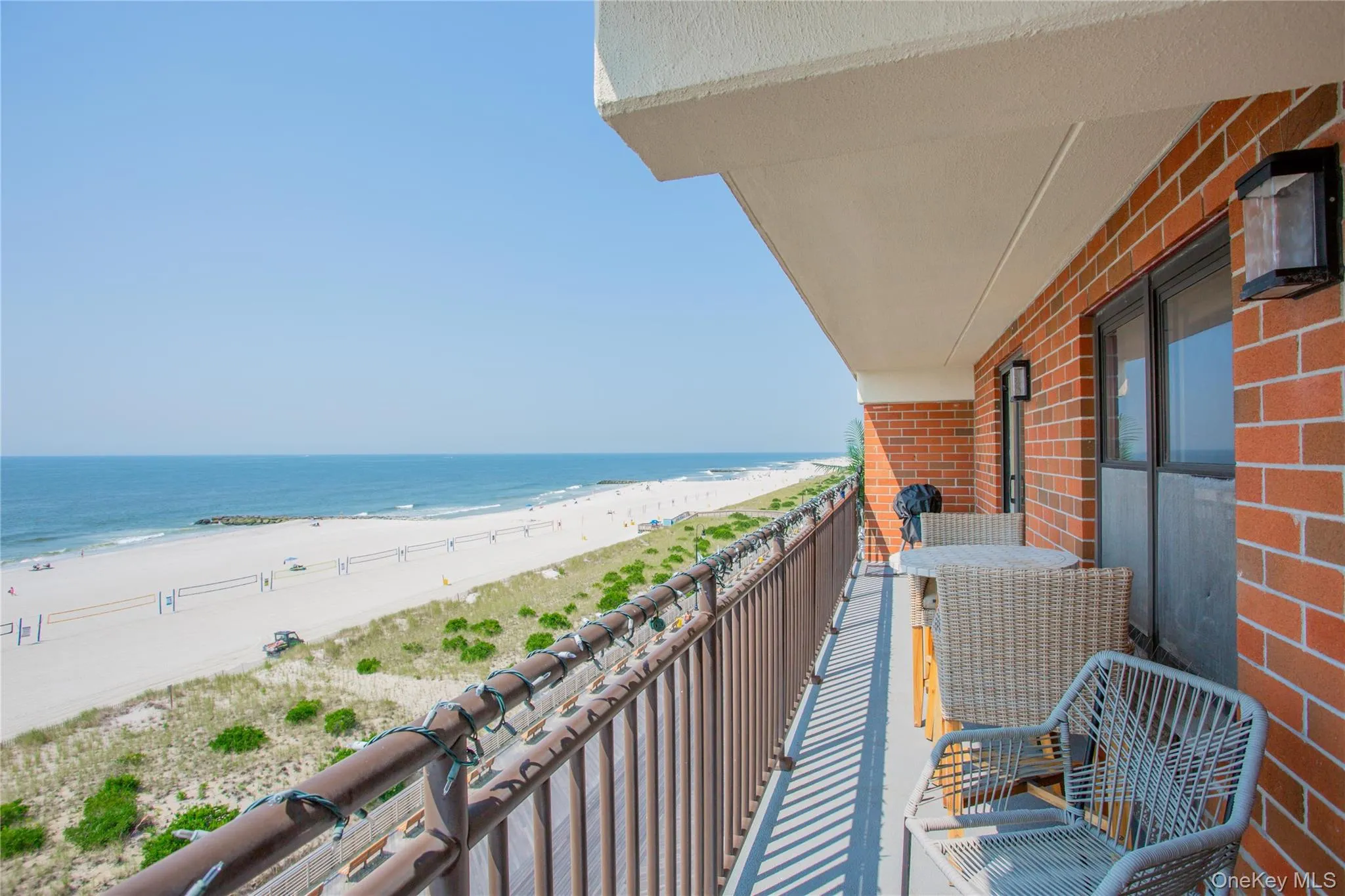 Balcony featuring view of water and beach and a sunroom Balcony featuring view of water and beach and a sunroom