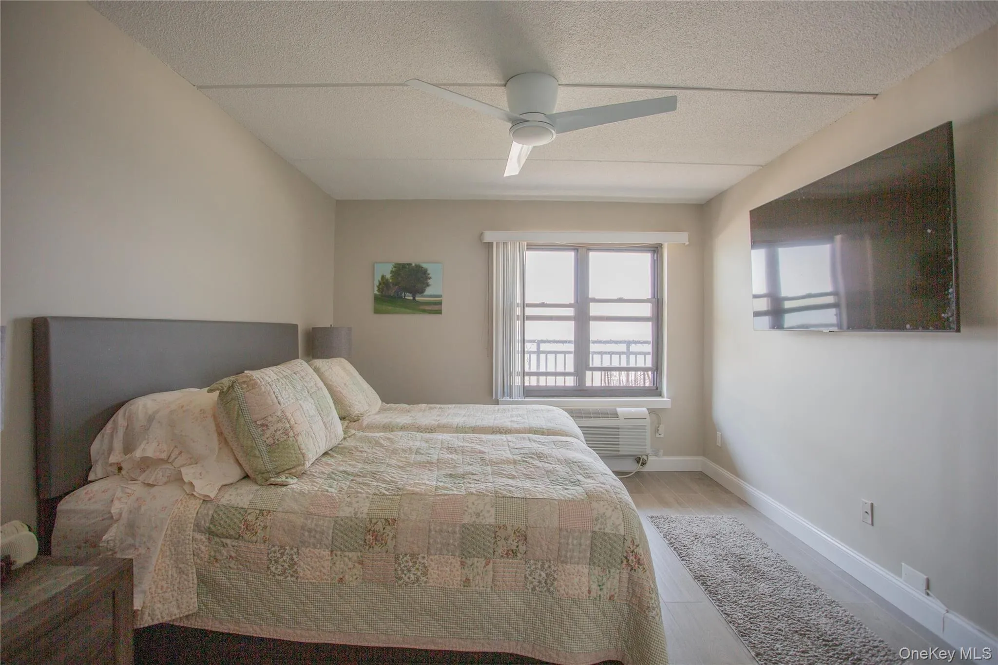 Bedroom with wood finished floors, a textured ceiling, and ceiling fan Bedroom with wood finished floors, a textured ceiling, and ceiling fan