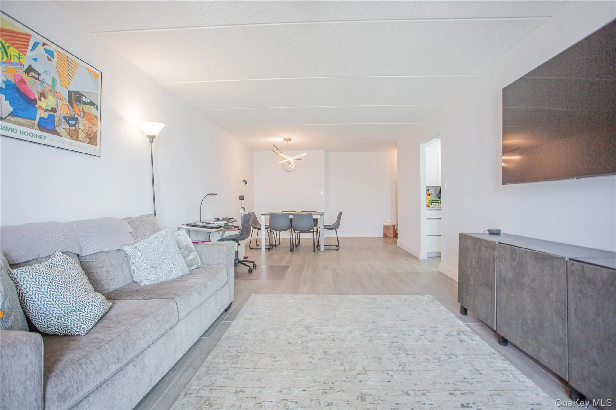 Living area with light wood-style floors and a chandelier Living area with light wood-style floors and a chandelier
