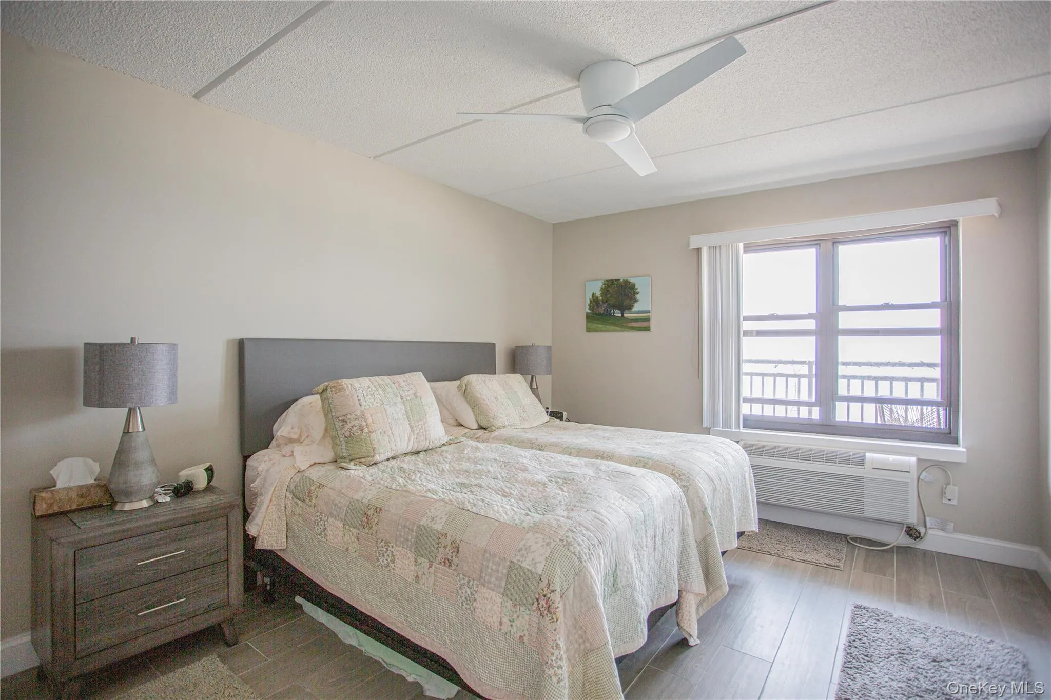 Bedroom featuring wood finished floors, a textured ceiling, and ceiling fan Bedroom featuring wood finished floors, a textured ceiling, and ceiling fan