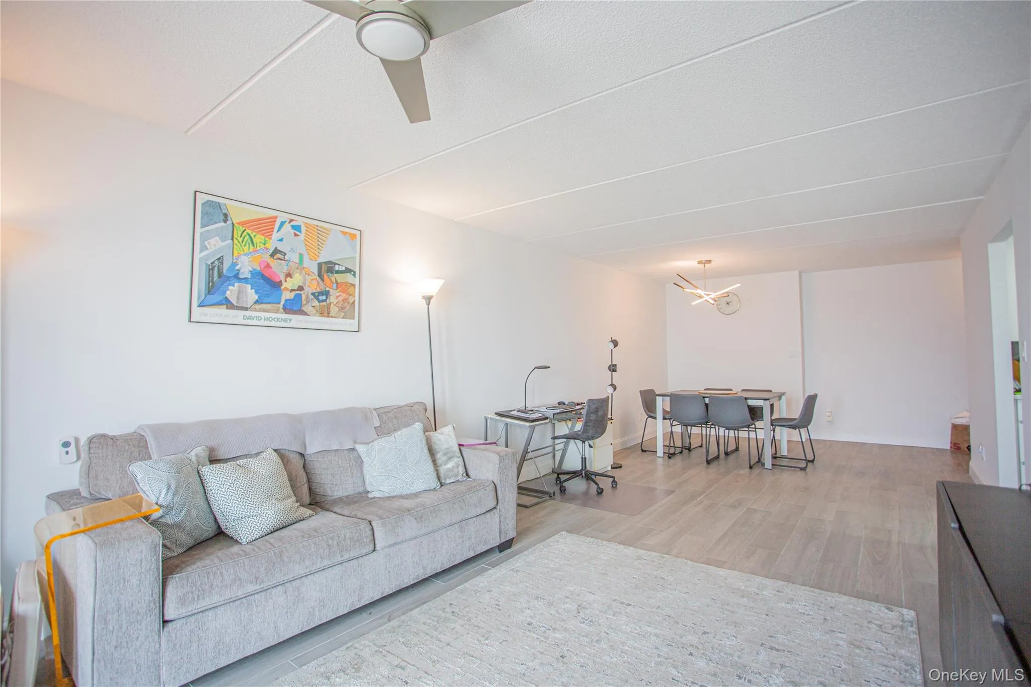 Living area with wood finished floors, a chandelier, and a ceiling fan Living area with wood finished floors, a chandelier, and a ceiling fan