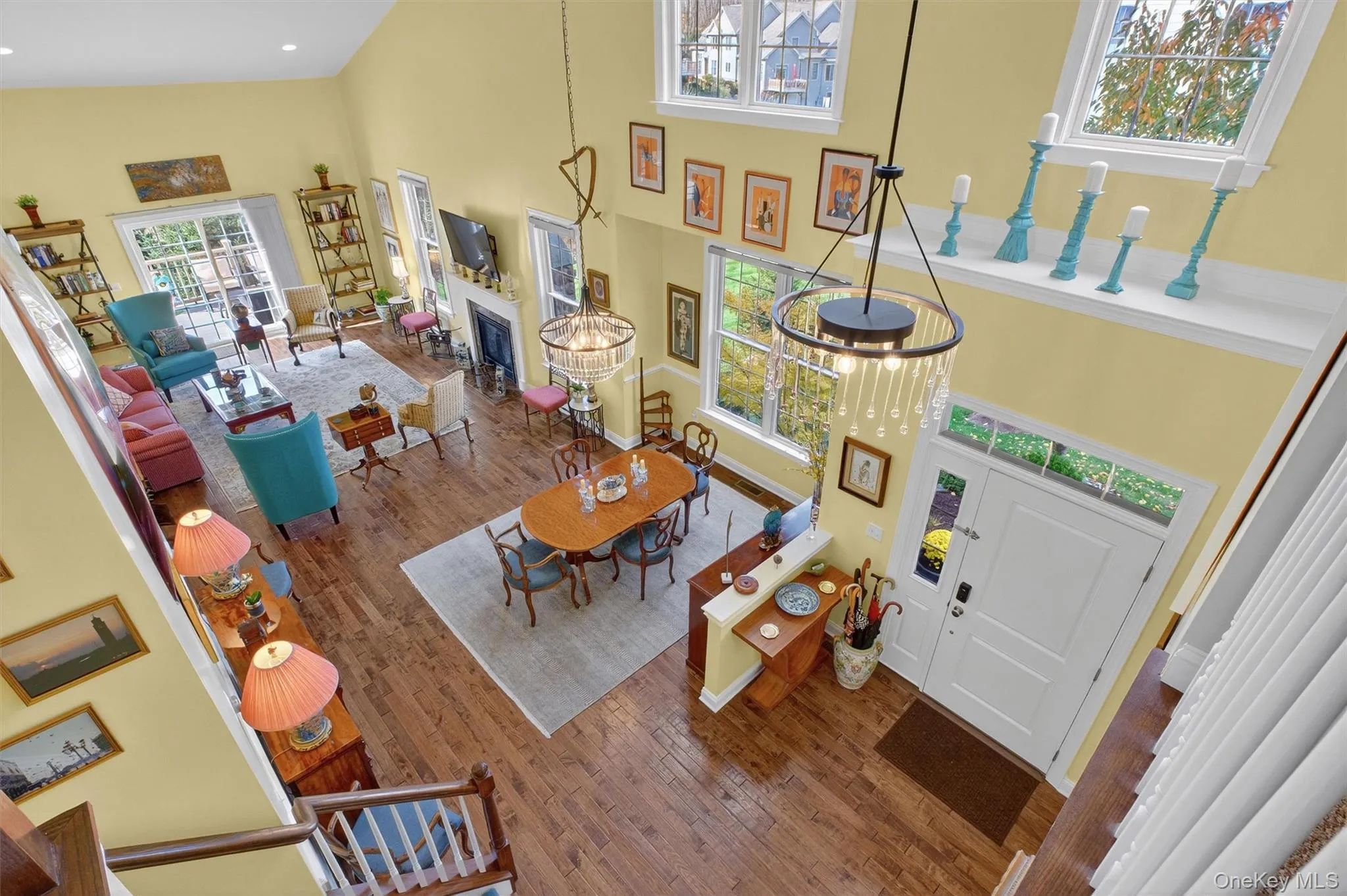 Living area featuring a high ceiling, wood-type flooring, and a fireplace Living area featuring a high ceiling, wood-type flooring, and a fireplace