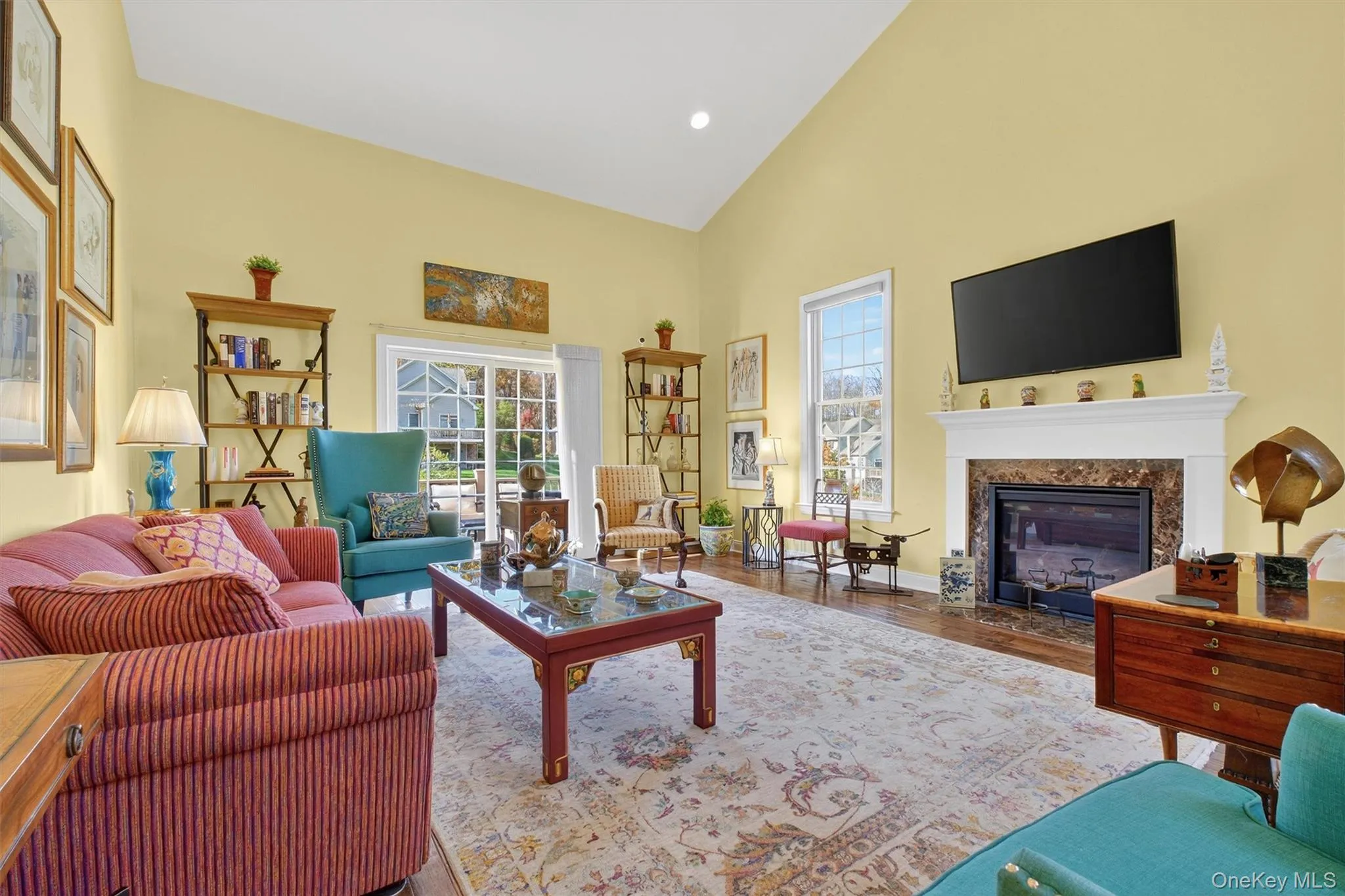 Living room with high vaulted ceiling, a high end fireplace, plenty of natural light, wood finished floors, and recessed lighting Living room with high vaulted ceiling, a high end fireplace, plenty of natural light, wood finished floors, and recessed lighting