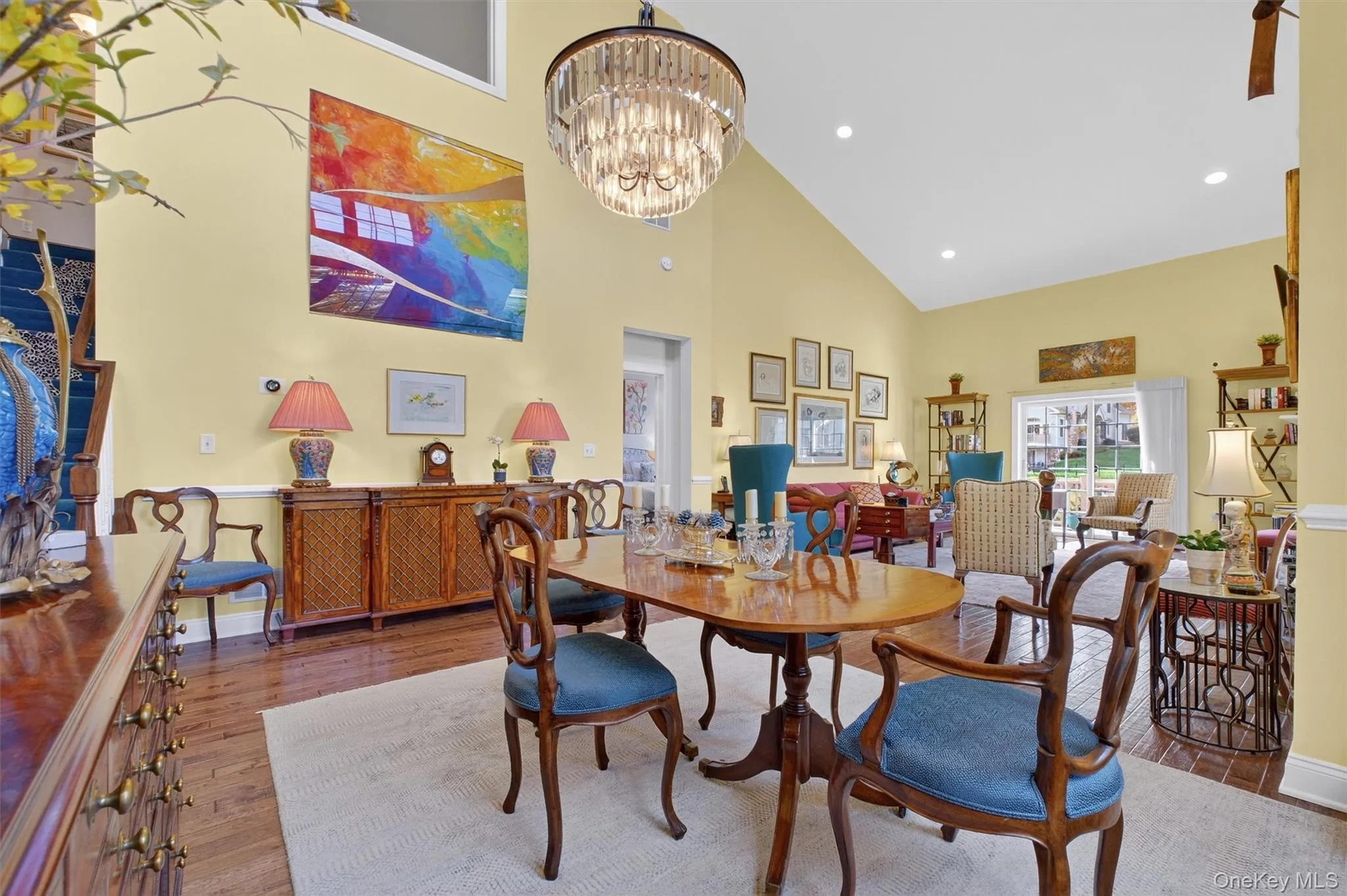 Dining area featuring high vaulted ceiling, wood finished floors, recessed lighting, and a chandelier Dining area featuring high vaulted ceiling, wood finished floors, recessed lighting, and a chandelier