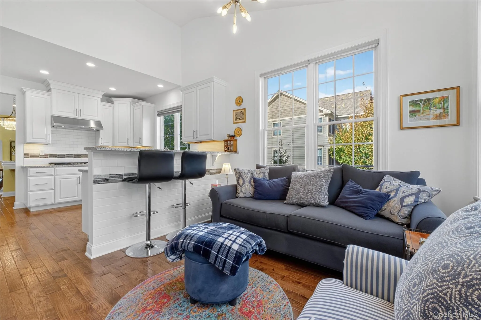 Living area with a chandelier, dark wood-style floors, recessed lighting, and lofted ceiling Living area with a chandelier, dark wood-style floors, recessed lighting, and lofted ceiling
