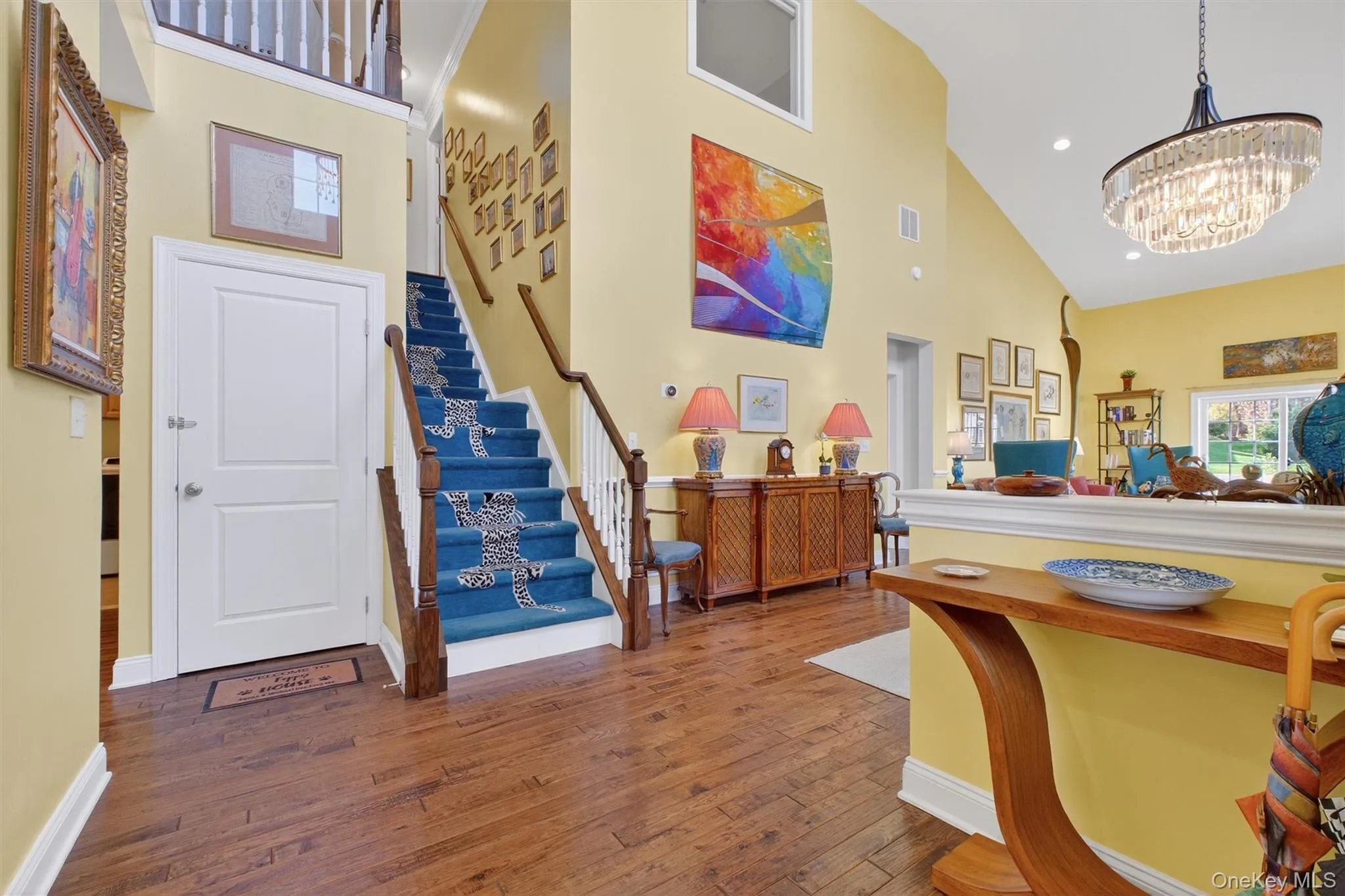 Foyer featuring high vaulted ceiling, hardwood / wood-style flooring, stairway, recessed lighting, and a chandelier Foyer featuring high vaulted ceiling, hardwood / wood-style flooring, stairway, recessed lighting, and a chandelier