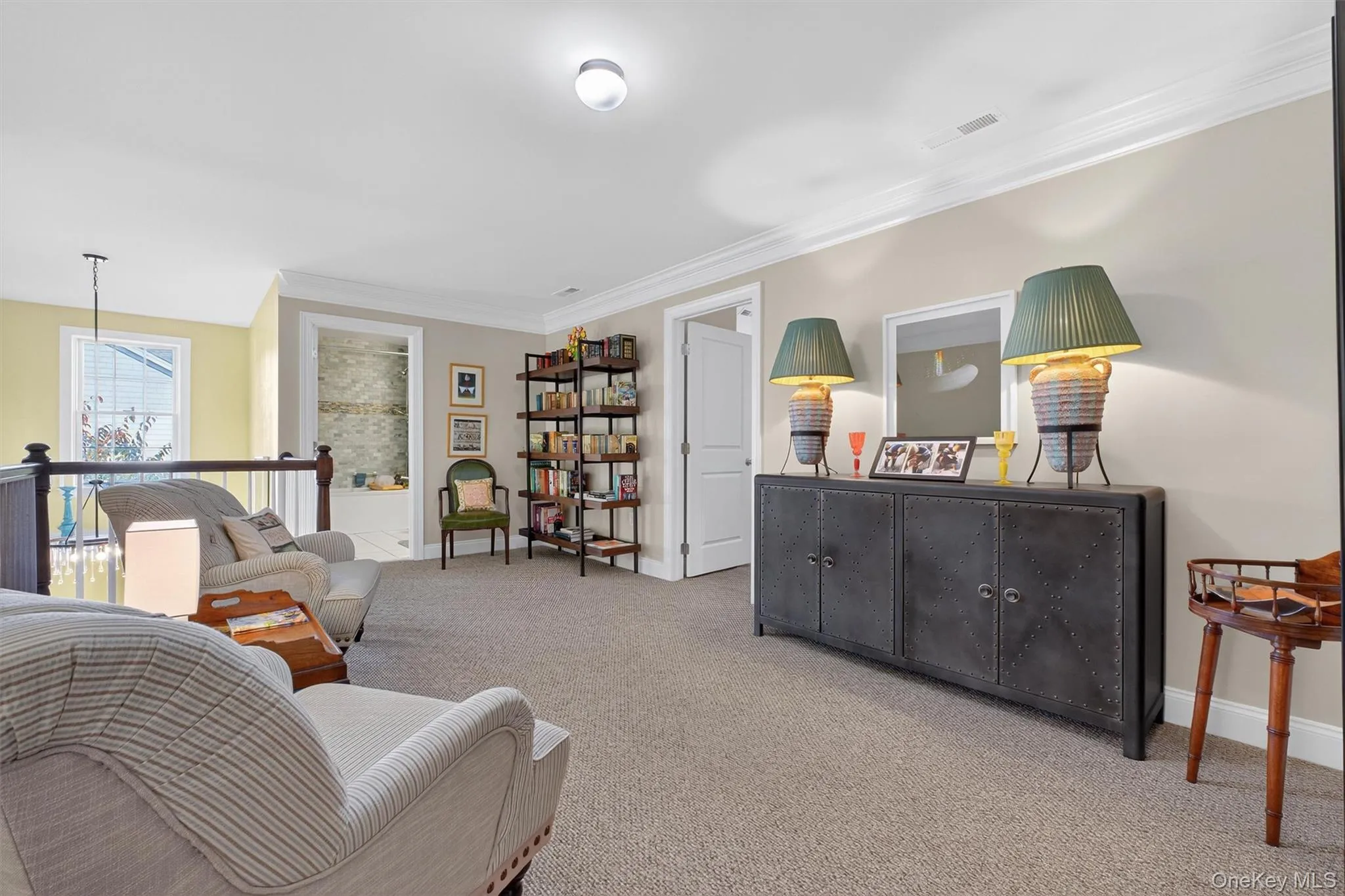Sitting room with carpet flooring, crown molding, and an upstairs landing Sitting room with carpet flooring, crown molding, and an upstairs landing