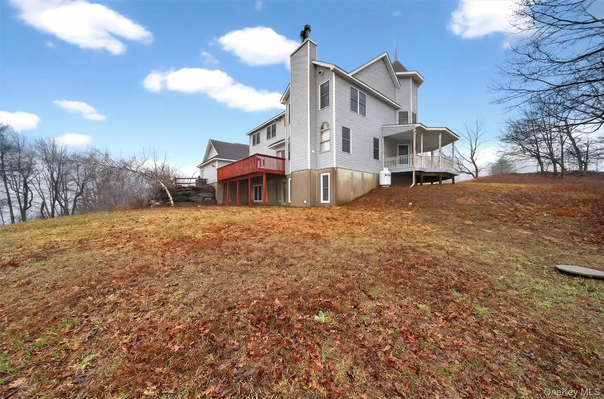 Back of house featuring a chimney, a deck, and a yard Back of house featuring a chimney, a deck, and a yard