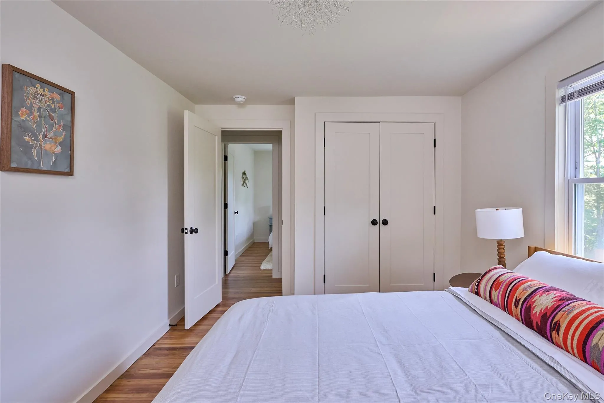 Bedroom featuring wood finished floors, baseboards, and a closet Bedroom featuring wood finished floors, baseboards, and a closet