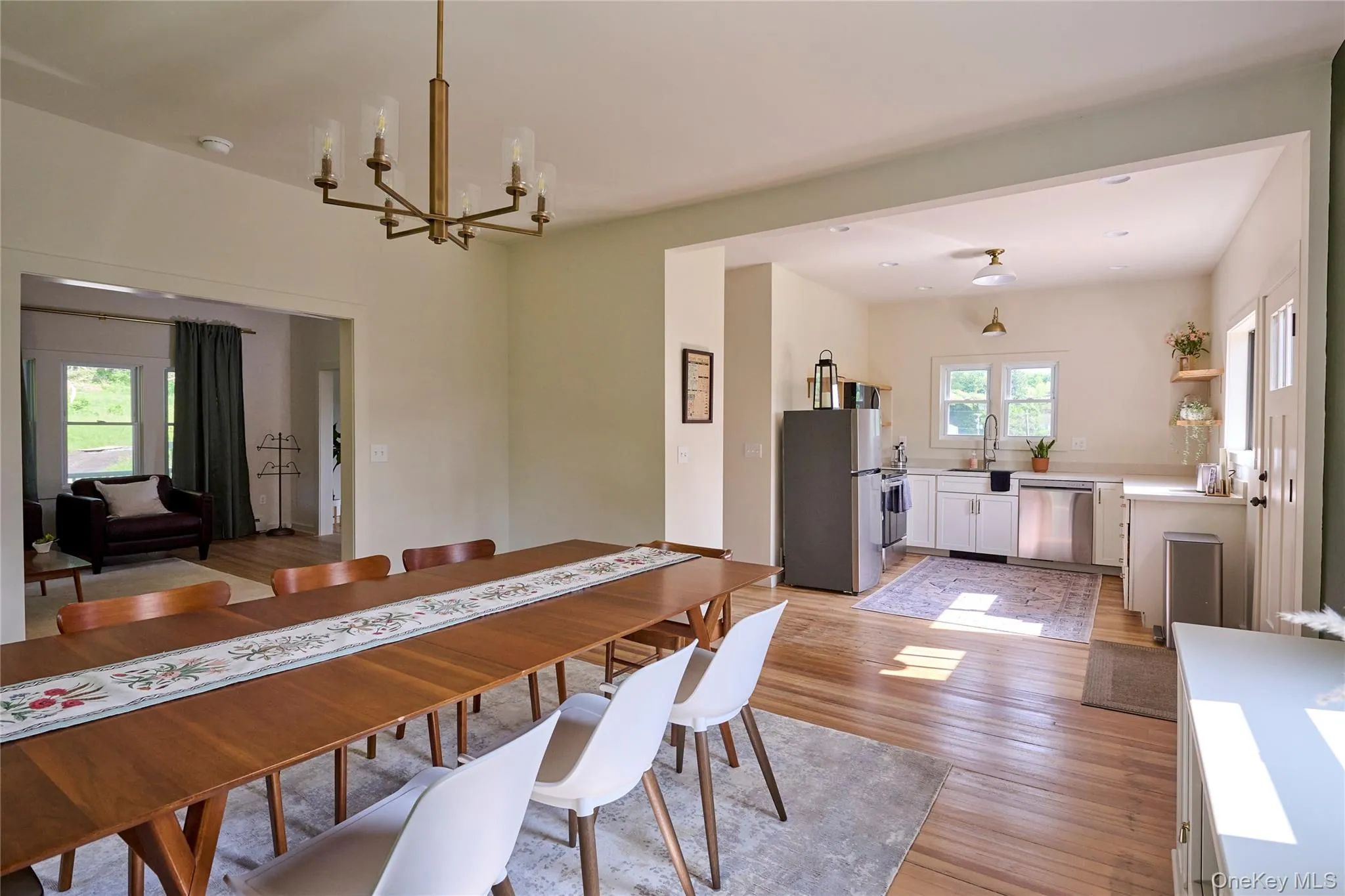 Dining area with a chandelier and light wood-style flooring Dining area with a chandelier and light wood-style flooring