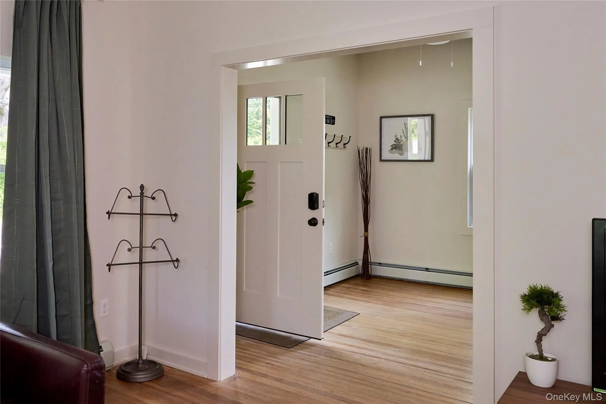 Entryway featuring light wood finished floors and a baseboard radiator Entryway featuring light wood finished floors and a baseboard radiator