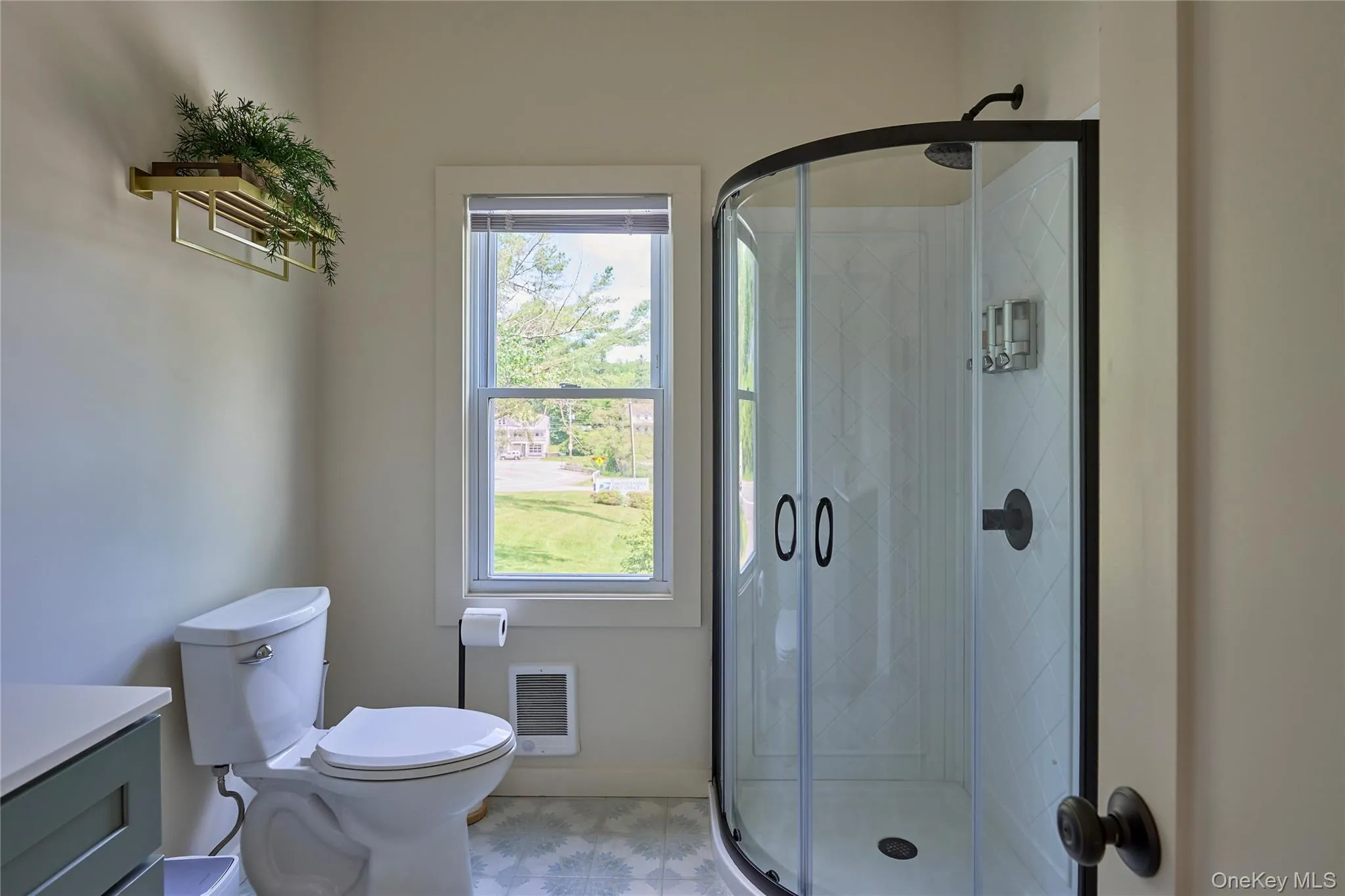 Bathroom featuring vanity, toilet, a shower stall, and heating unit Bathroom featuring vanity, toilet, a shower stall, and heating unit