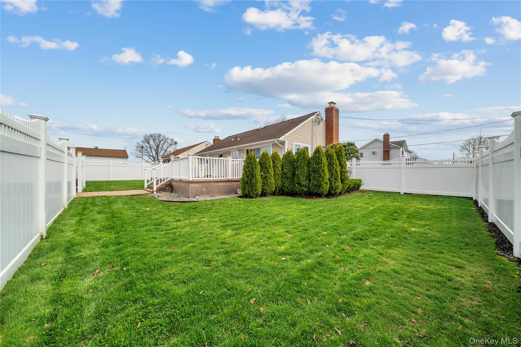 Fenced backyard featuring a wooden deck Fenced backyard featuring a wooden deck