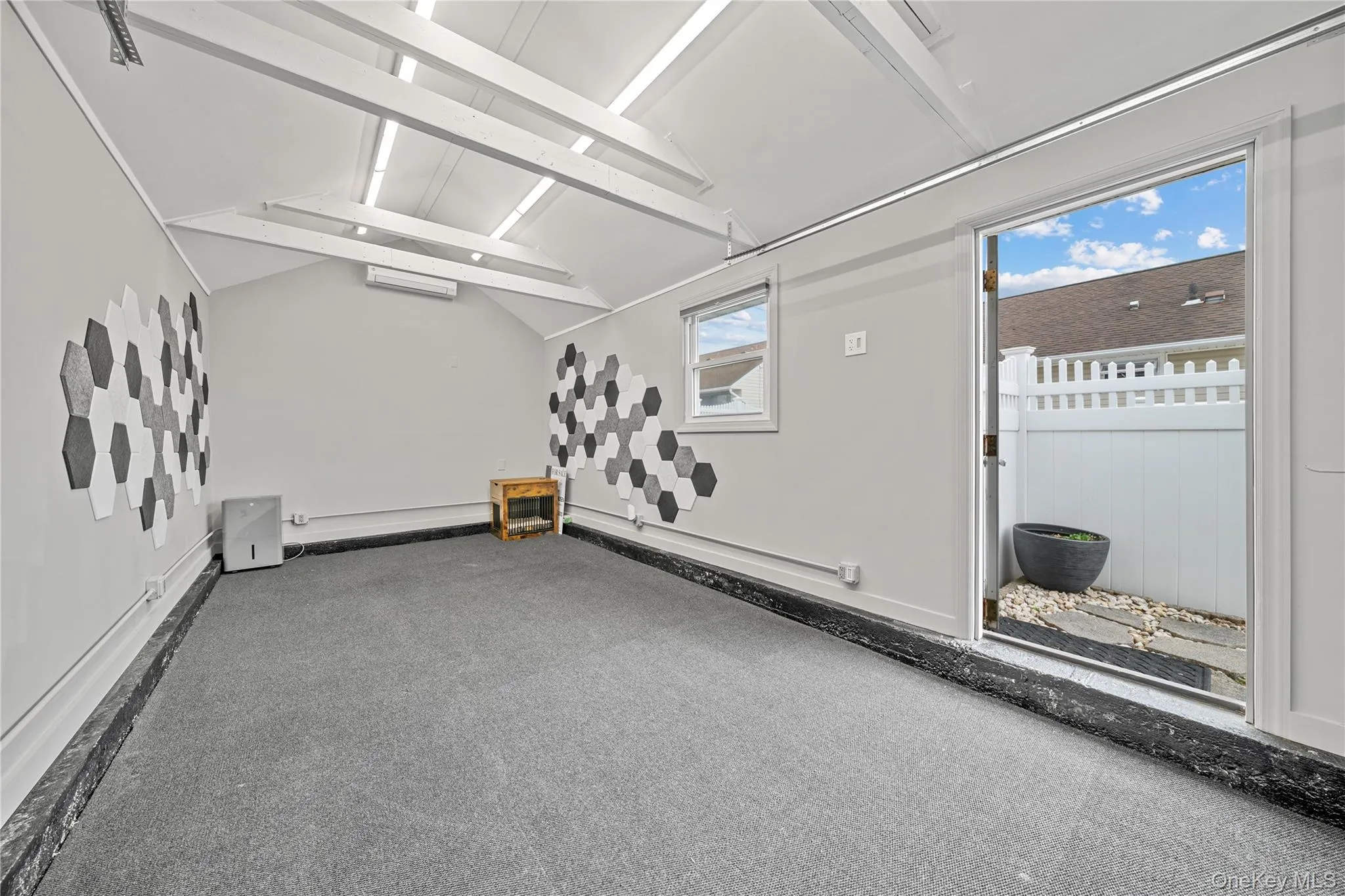 Carpeted spare room with beam ceiling and split ac and heat Carpeted spare room with beam ceiling and split ac and heat