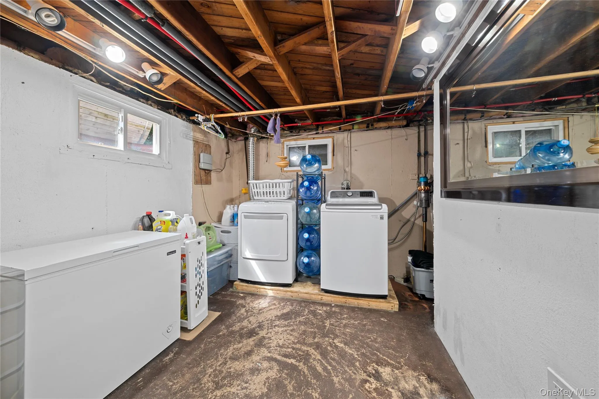 Laundry area with unfinished concrete flooring and washer and dryer Laundry area with unfinished concrete flooring and washer and dryer