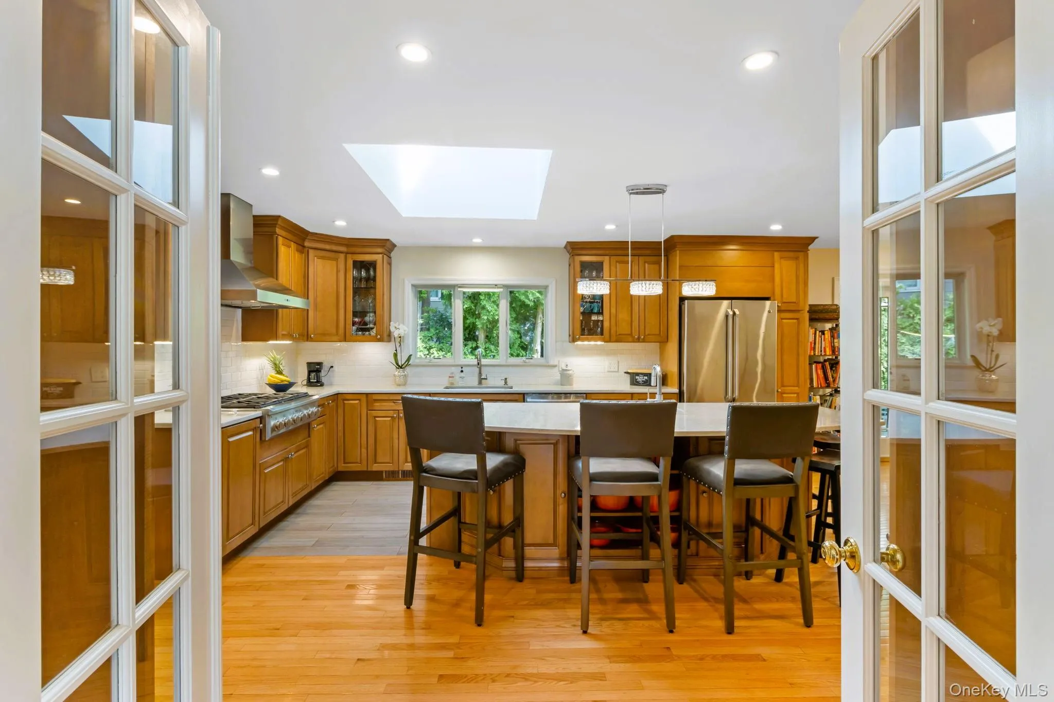 Kitchen with stainless steel appliances, a skylight, and oversized island Kitchen with stainless steel appliances, a skylight, and oversized island
