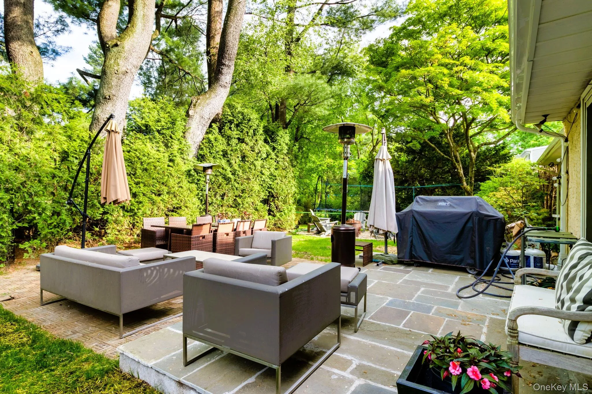 View of patio featuring grilling area, an outdoor hangout area, and view of scattered trees View of patio featuring grilling area, an outdoor hangout area, and view of scattered trees