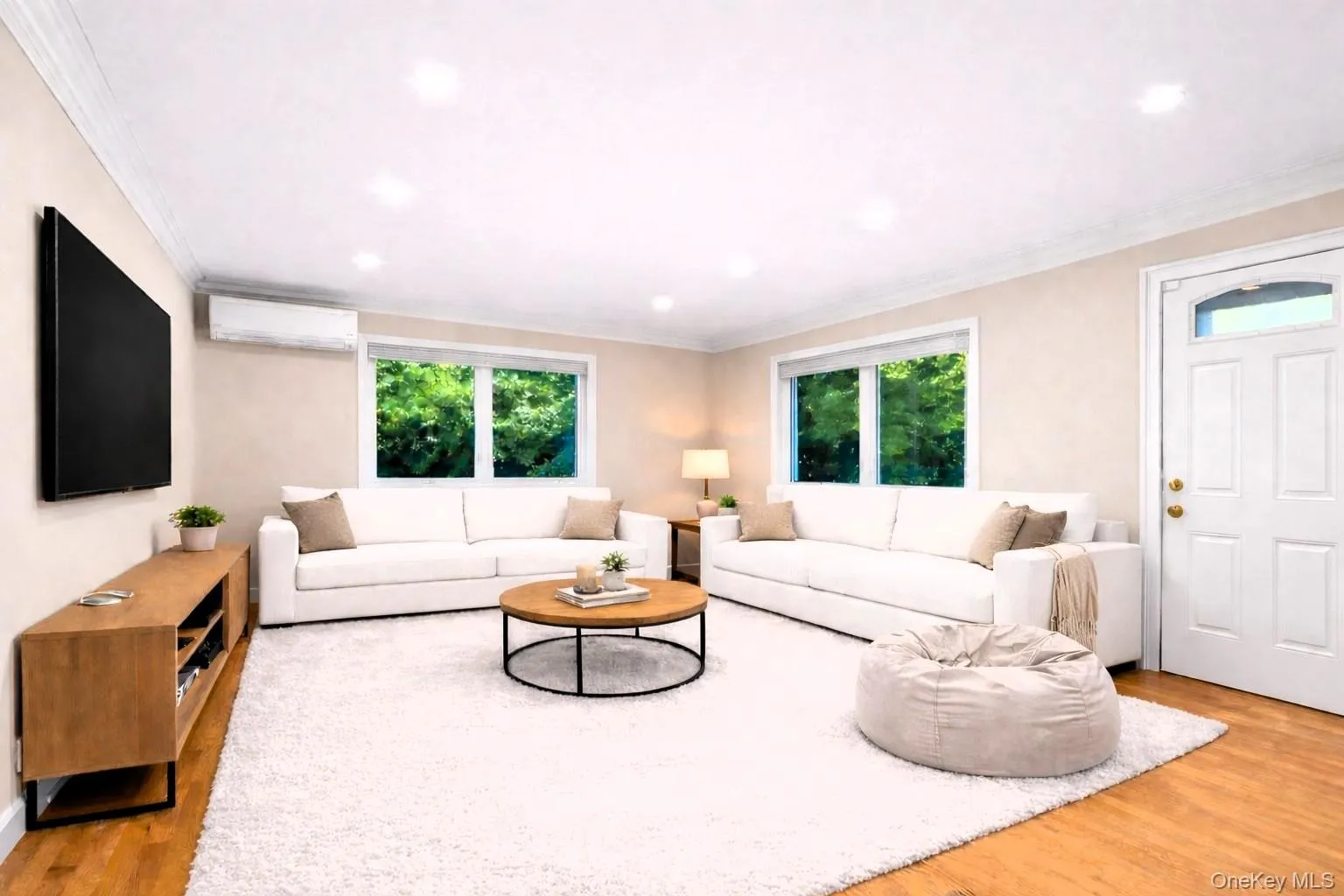 Family Room with an split unit, wood finished floors, healthy amount of natural light, ornamental molding, and a chandelier Family Room with an split unit, wood finished floors, healthy amount of natural light, ornamental molding, and a chandelier