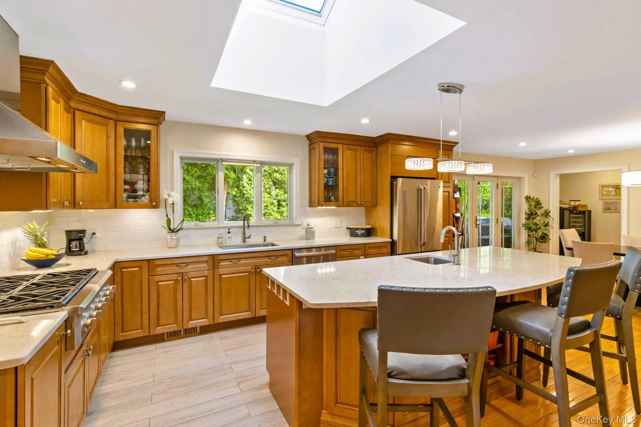 Kitchen with stainless steel appliances, a skylight, and oversized island Kitchen with stainless steel appliances, a skylight, and oversized island