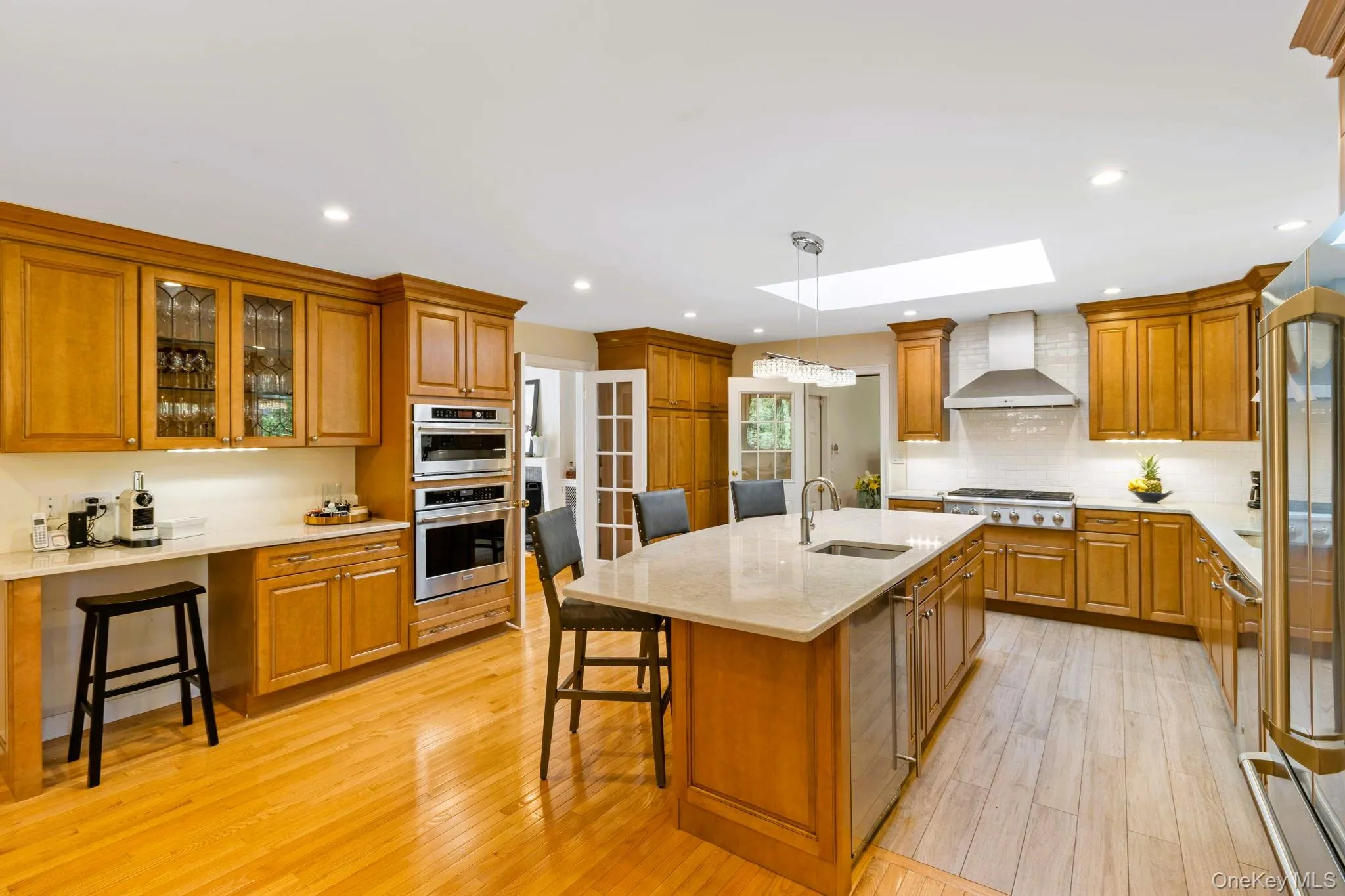 Kitchen with stainless steel appliances, a skylight, and oversized island Kitchen with stainless steel appliances, a skylight, and oversized island