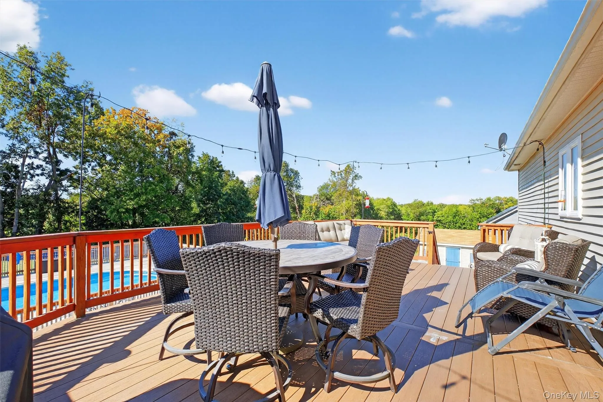 Wooden deck featuring outdoor dining area and an outdoor pool Wooden deck featuring outdoor dining area and an outdoor pool