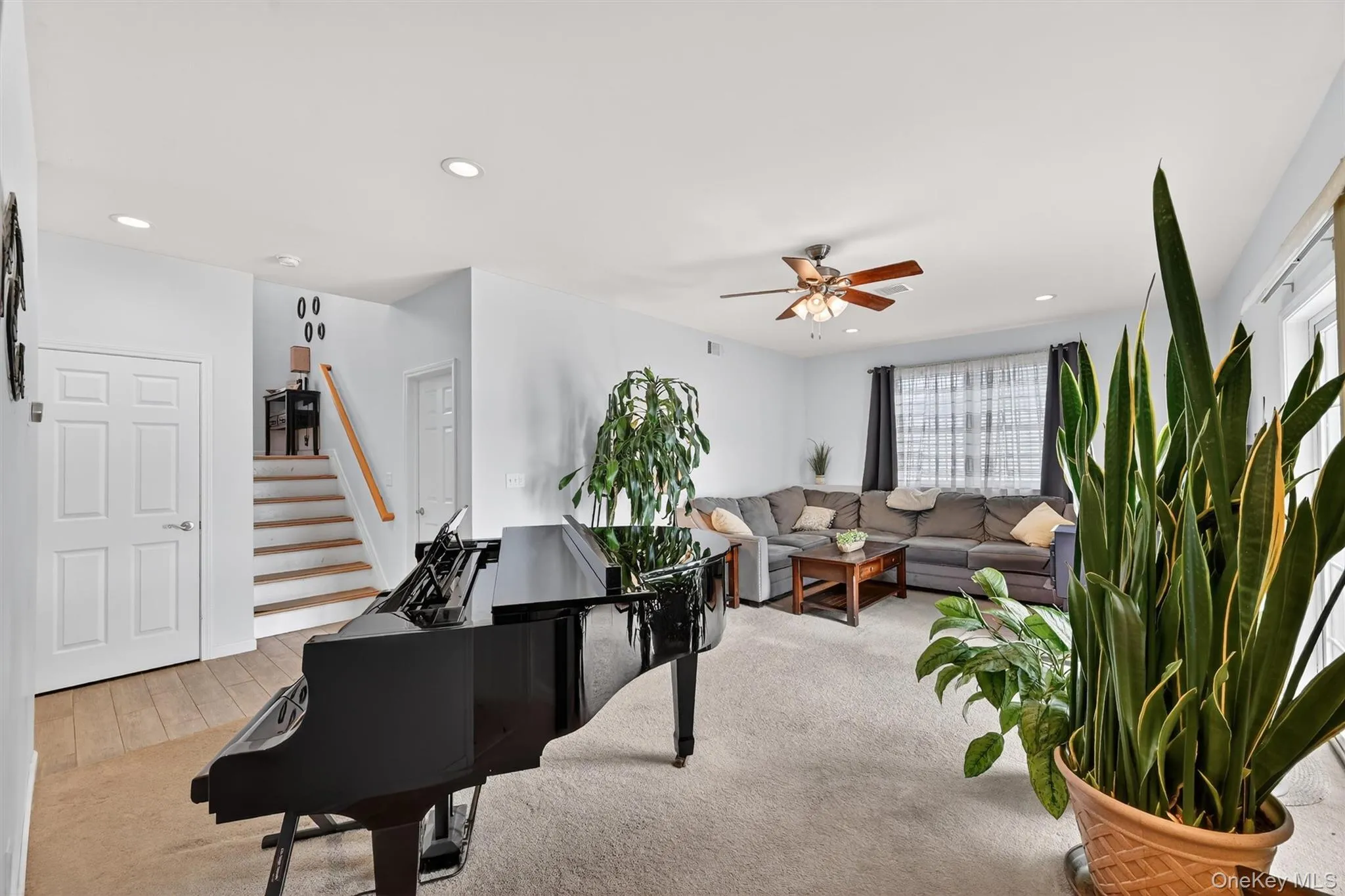 Living area featuring recessed lighting, light colored carpet, and a ceiling fan Living area featuring recessed lighting, light colored carpet, and a ceiling fan