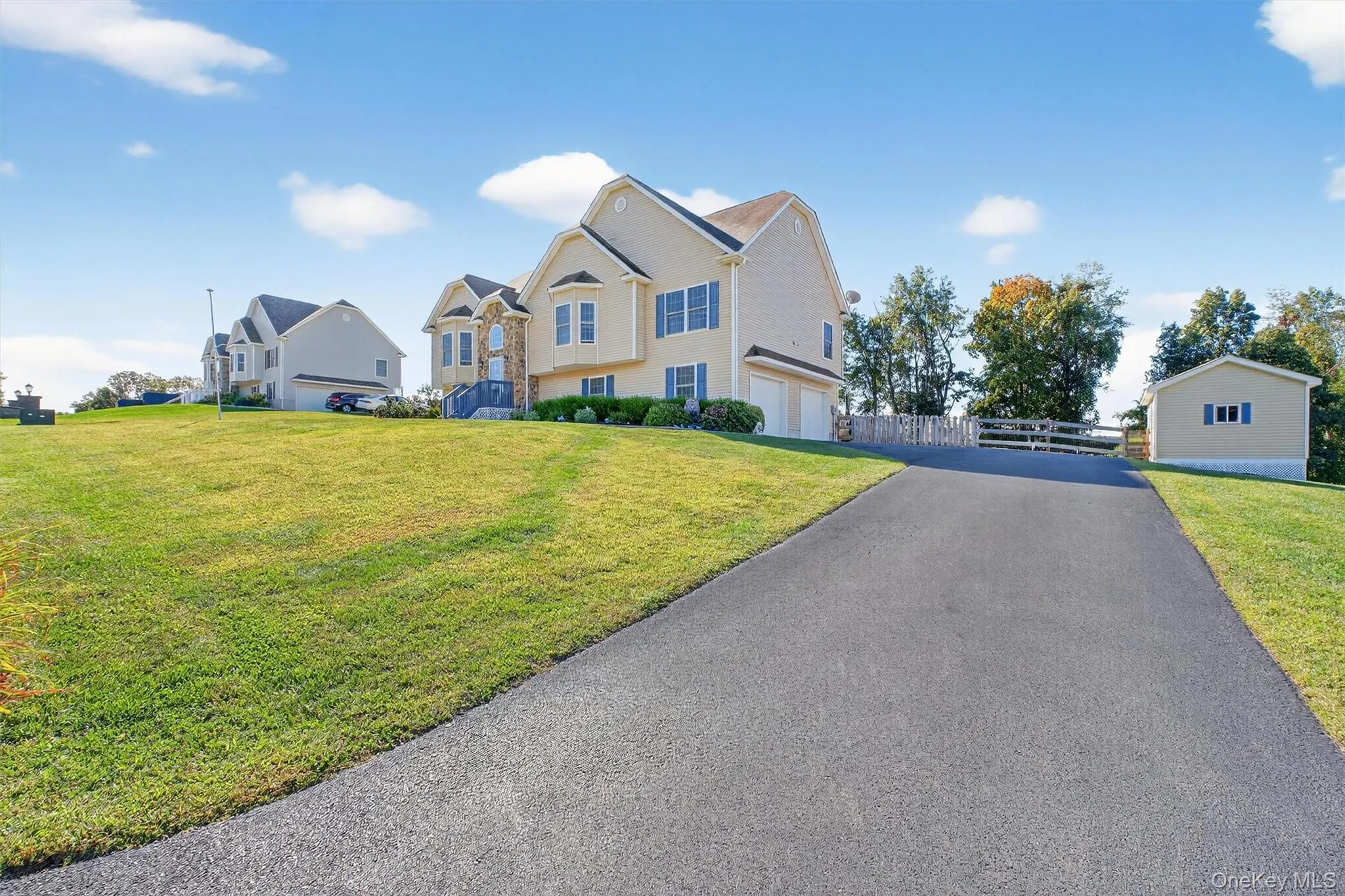 Bi-level home featuring asphalt driveway and a garage Bi-level home featuring asphalt driveway and a garage