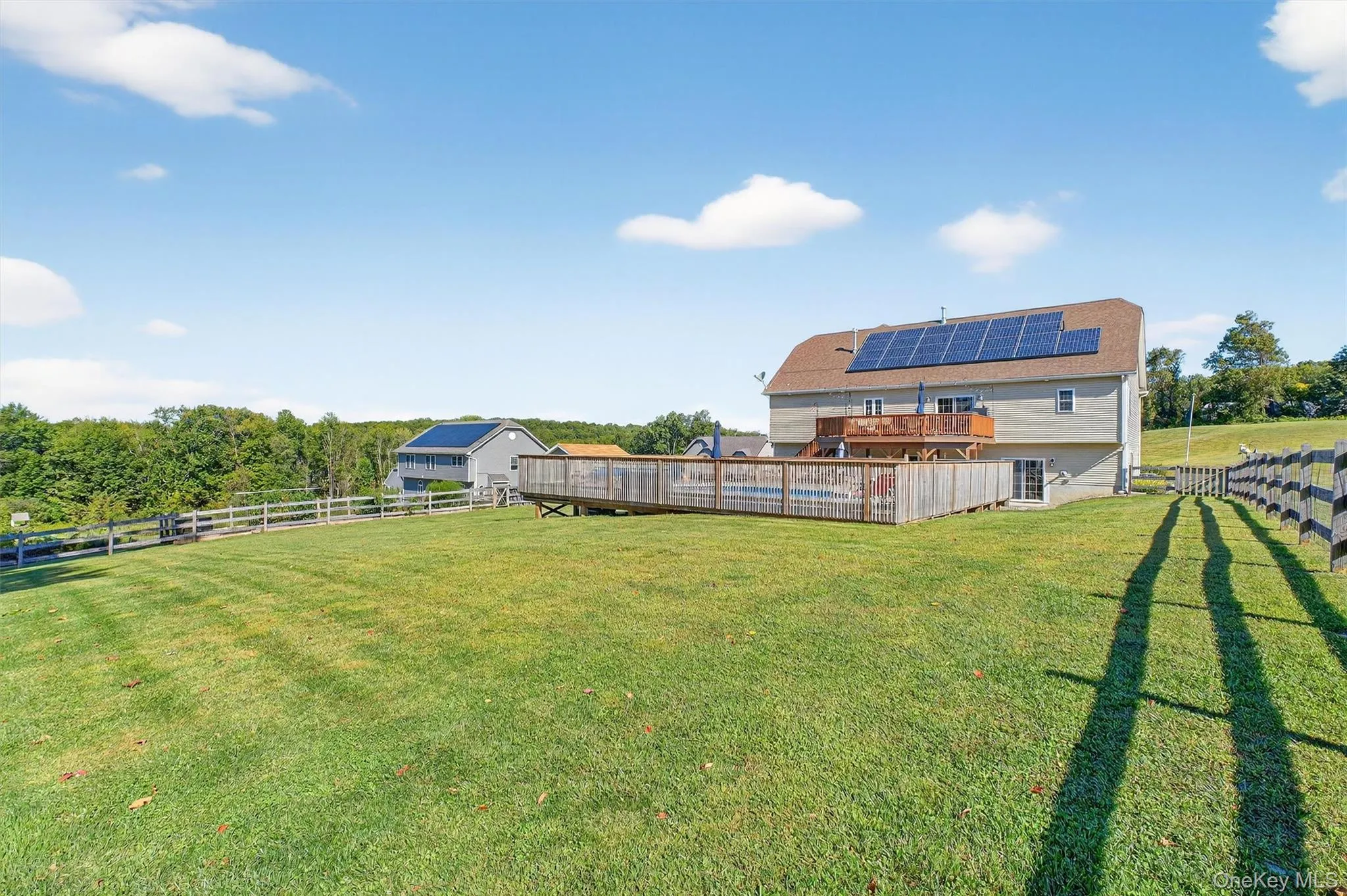 Fenced backyard featuring a view of rural / pastoral area and a deck Fenced backyard featuring a view of rural / pastoral area and a deck