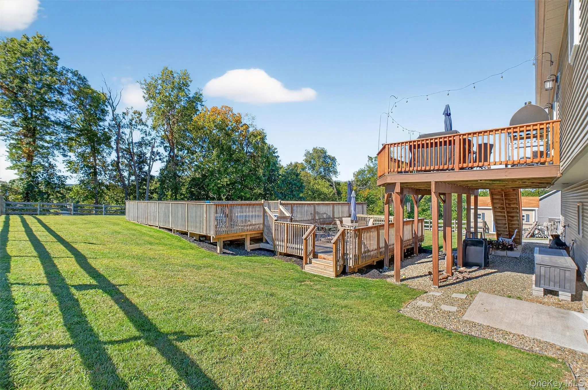 Fenced backyard featuring a deck and a patio area Fenced backyard featuring a deck and a patio area