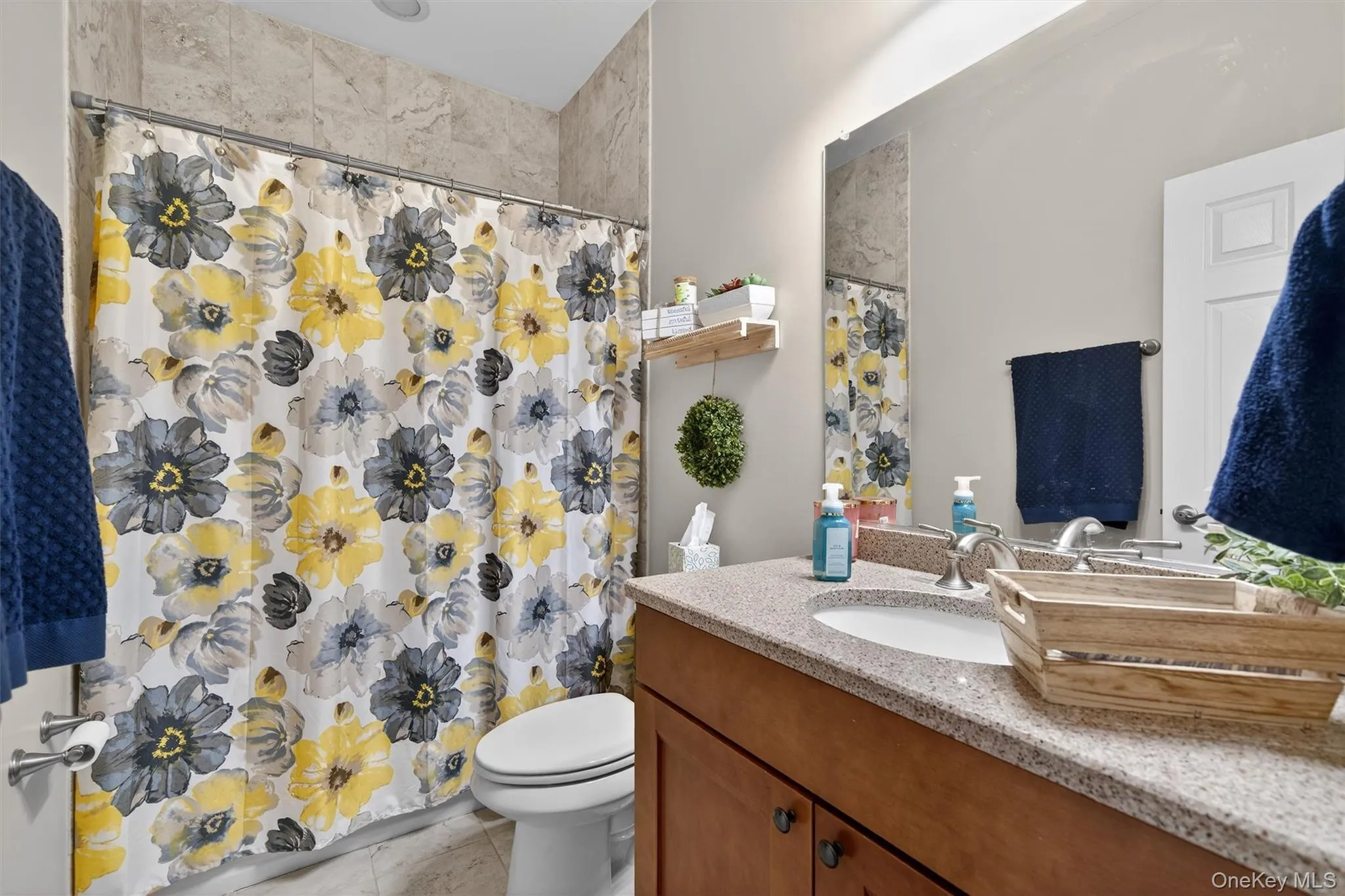 Full bathroom with vanity, curtained shower, and light tile patterned floors Full bathroom with vanity, curtained shower, and light tile patterned floors