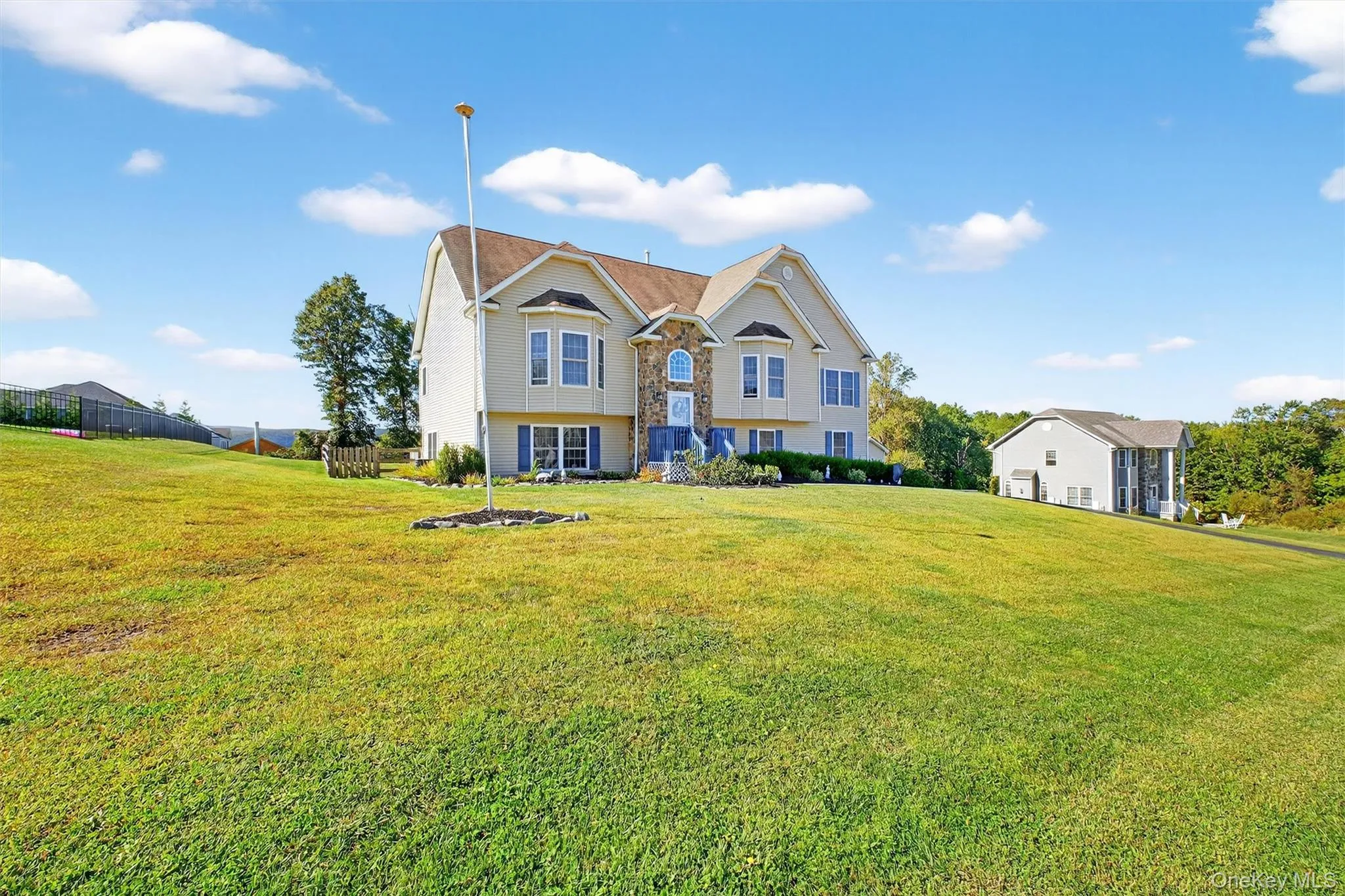 Split foyer home featuring a front lawn and stone siding Split foyer home featuring a front lawn and stone siding