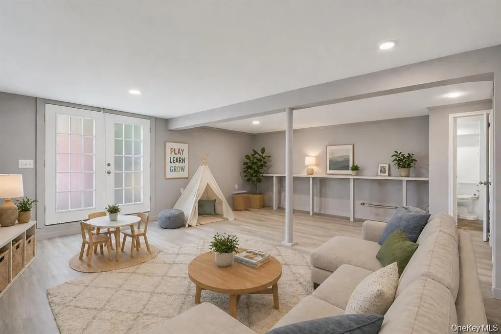 Finished lower level featuring light-toned wood-finish flooring, recessed lighting, and a neutral color palette Finished lower level featuring light-toned wood-finish flooring, recessed lighting, and a neutral color palette