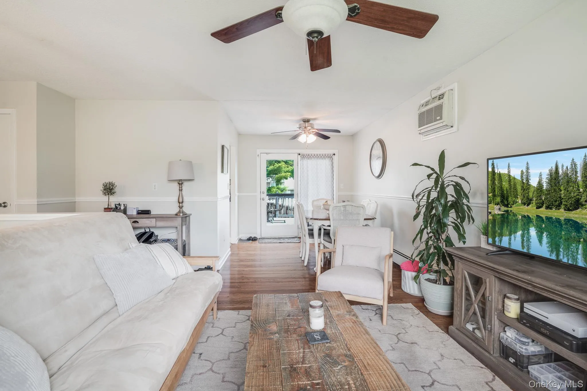 Living area with light-toned walls and wood-finish flooring Living area with light-toned walls and wood-finish flooring