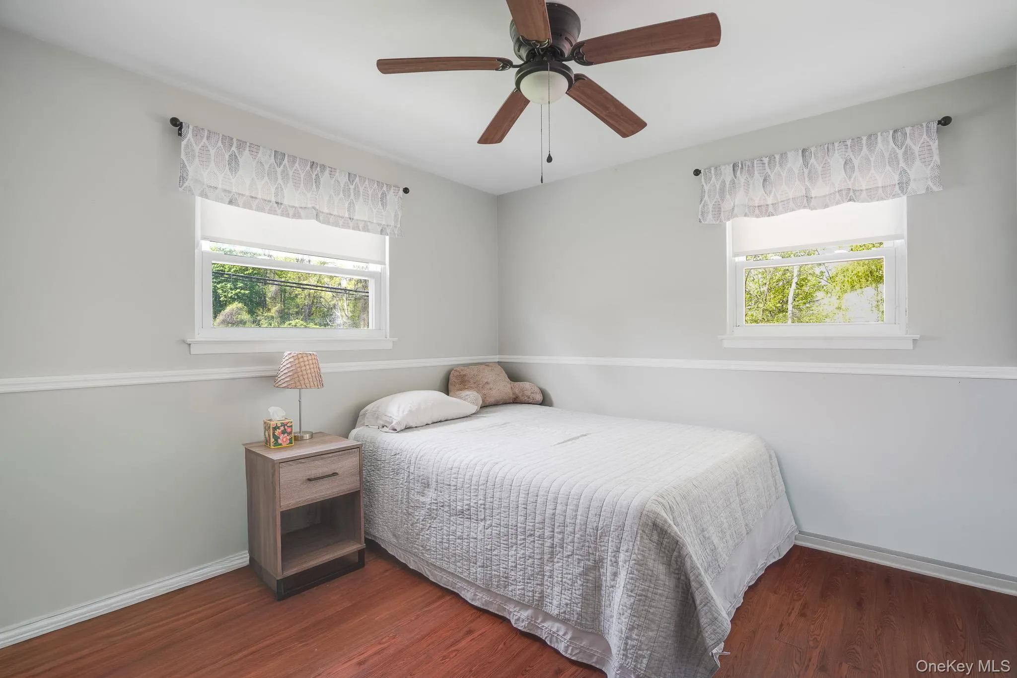 Bright room featuring two windows with valances and white trim Bright room featuring two windows with valances and white trim