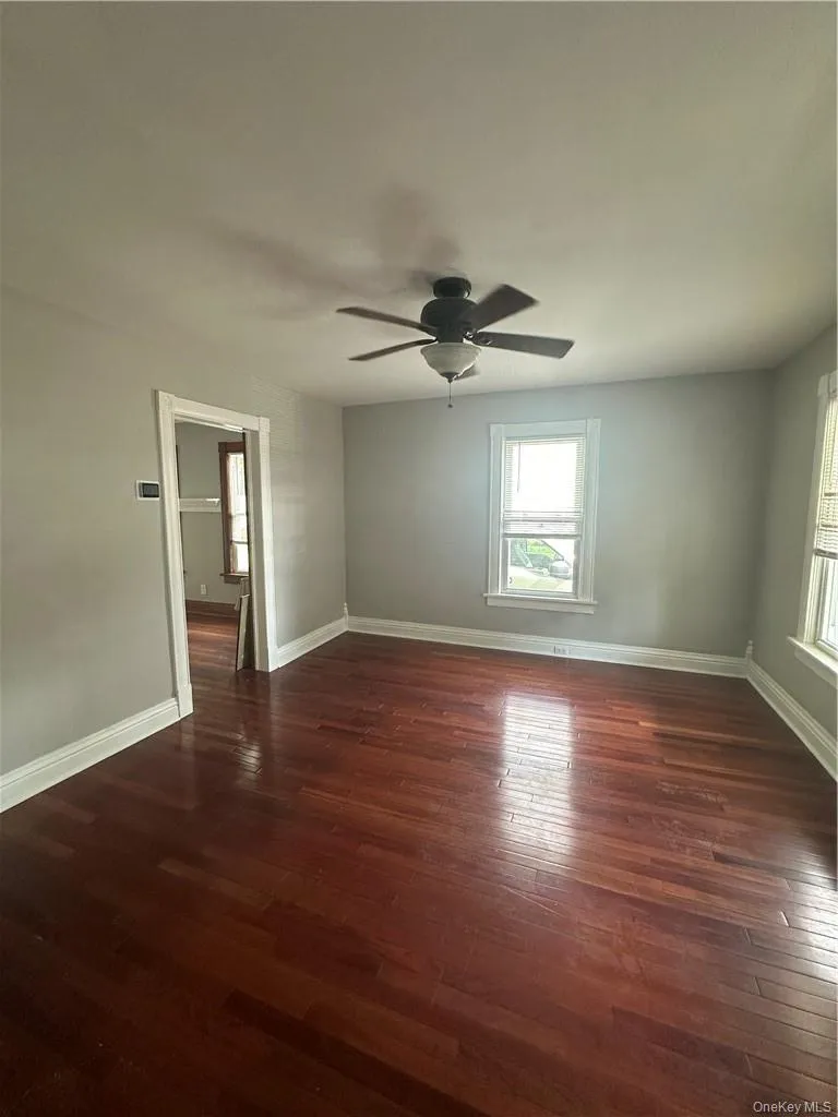Living room with high ceilings, hardwood floors and entry into dining room Living room with high ceilings, hardwood floors and entry into dining room