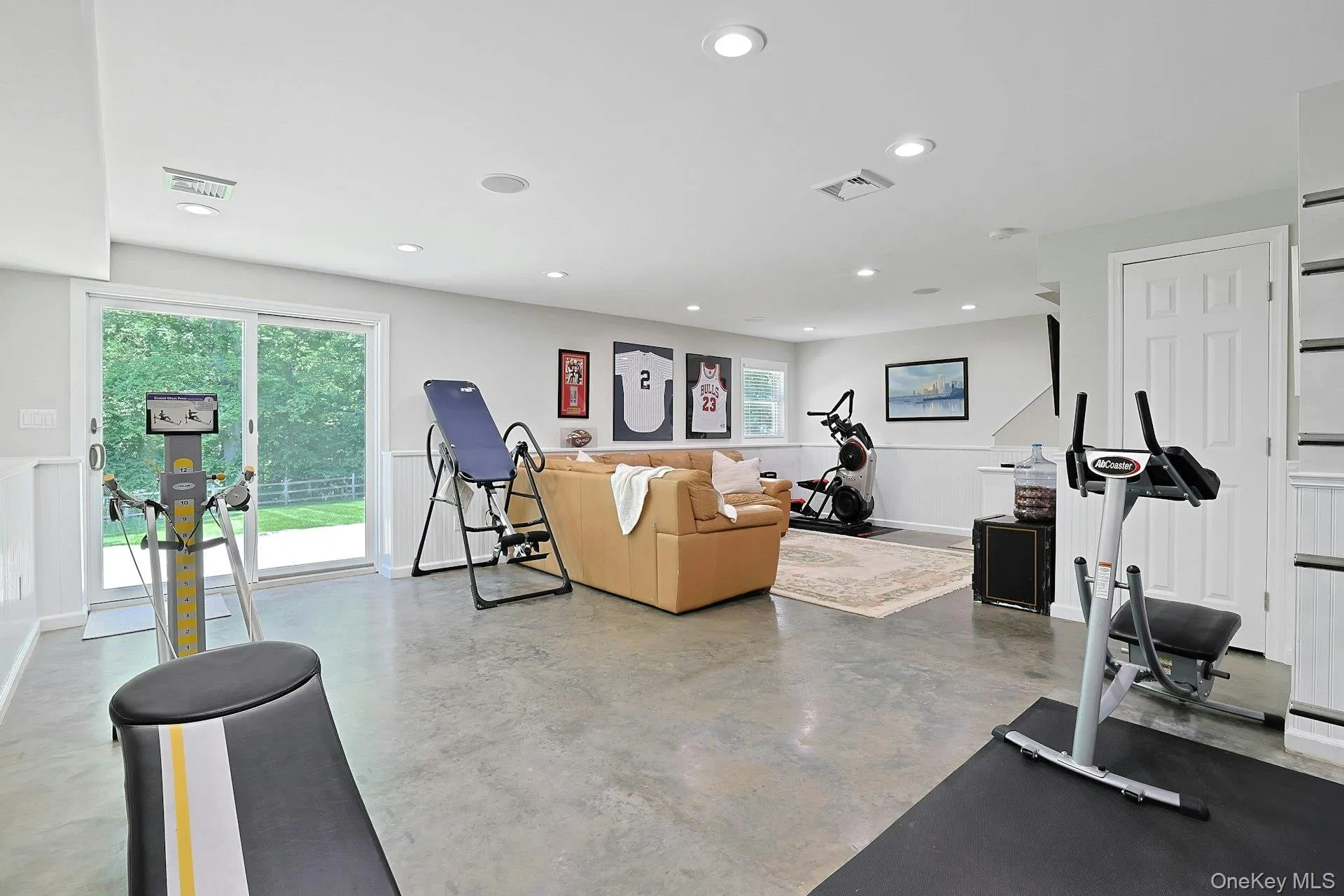 Spacious recreation room/TV room with beadboard trim, concrete floor and sliders to back yard. Spacious recreation room/TV room with beadboard trim, concrete floor and sliders to back yard.