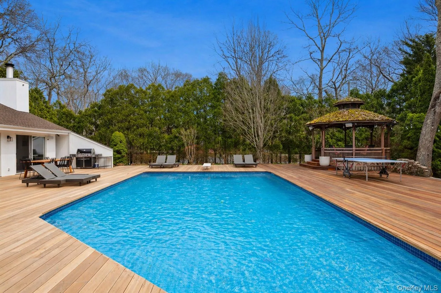 Expansive outdoor living area featuring a heated, gunite pool and a built-in gazebo Expansive outdoor living area featuring a heated, gunite pool and a built-in gazebo